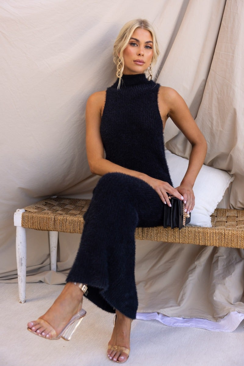 Black fluffy knit maxi dress with high neckline, worn by model, showcasing a relaxed fit and elegant style.