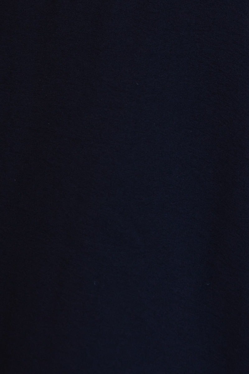 Close-up of the fabric texture of the Amos Dress, featuring a deep black color, showcasing smooth rayon material.