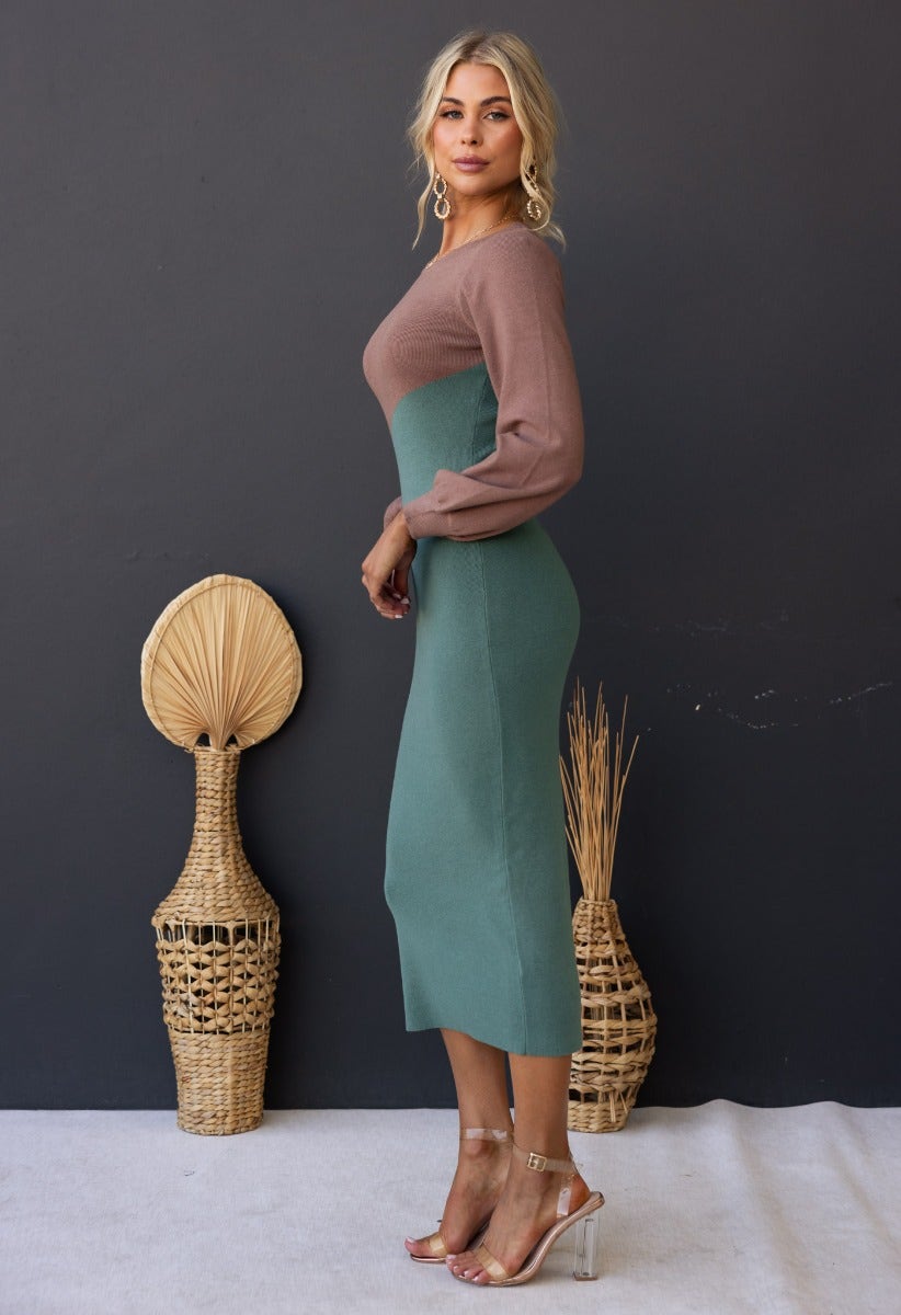 Model wearing the Torez Midi Dress, featuring a round neckline and bishop sleeves, in a ribbed green and brown design.