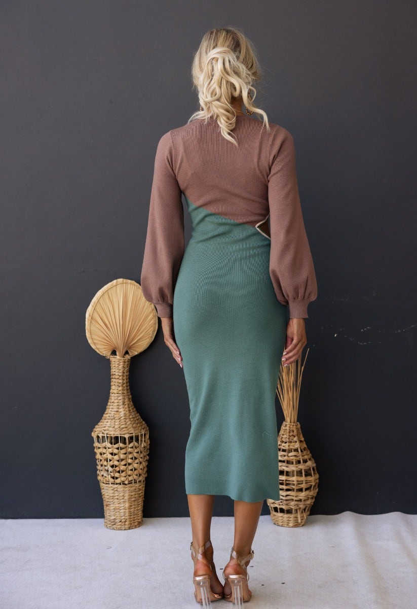 Model wearing Torez Midi Dress featuring bishop sleeves, round neckline, and cut-out at waist against a neutral background.