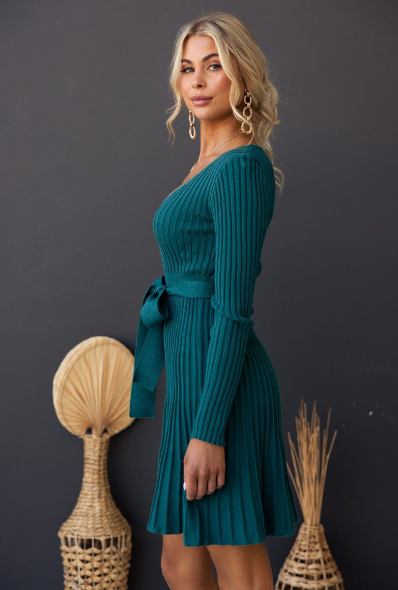 Model wearing the Cadello Dress in teal, showcasing ribbed knit fabric, round neckline, and removable belt.