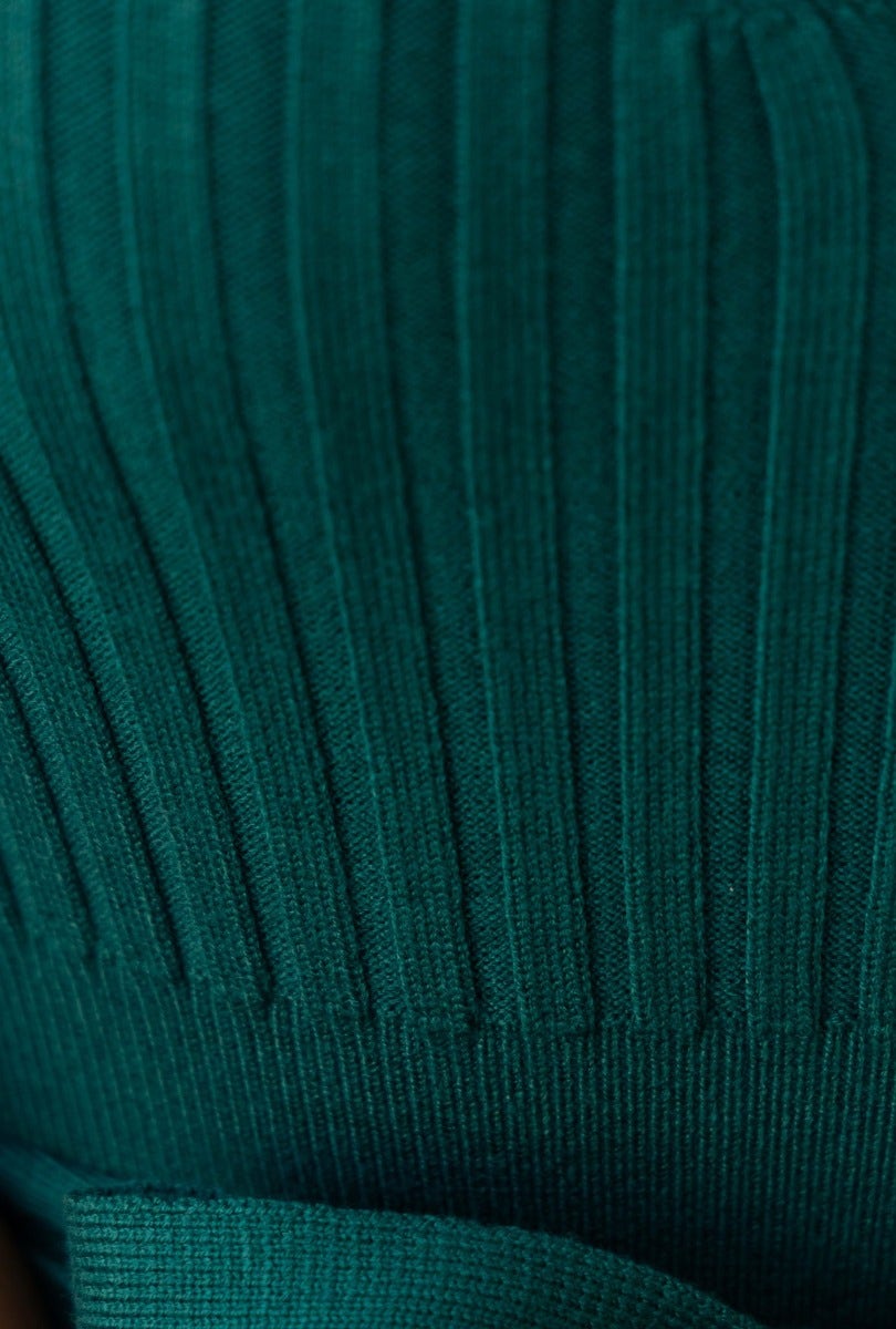 Close-up of ribbed knit material in deep green, showcasing the texture for the Cadello Dress.
