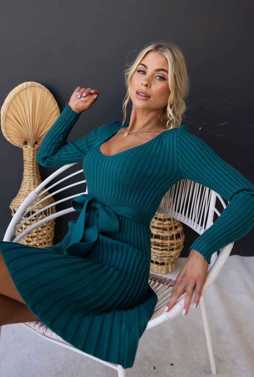 Taylah models the Cadello Dress in teal, featuring a ribbed knit design, round neckline, and removable fabric belt.