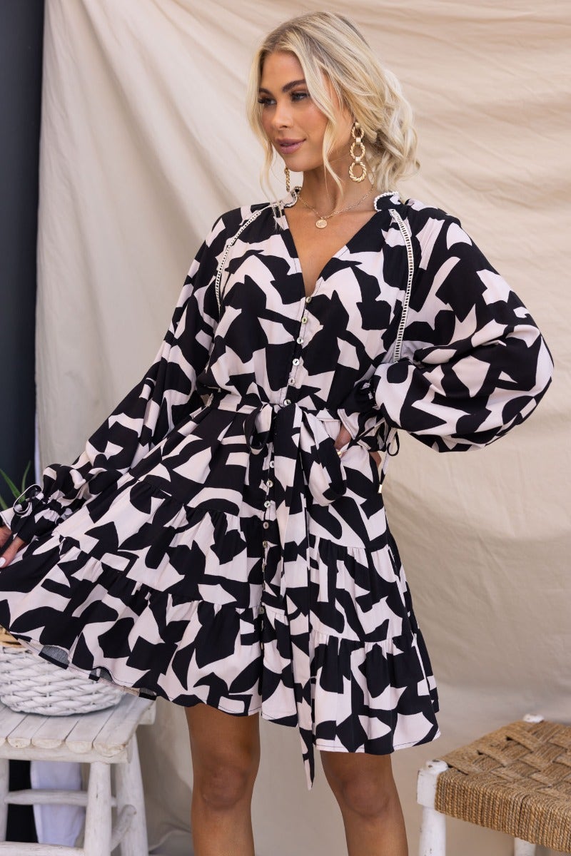 Stylish Hasley Dress featuring a black and white abstract print, V-neckline, elastic cuffs, and removable belt.
