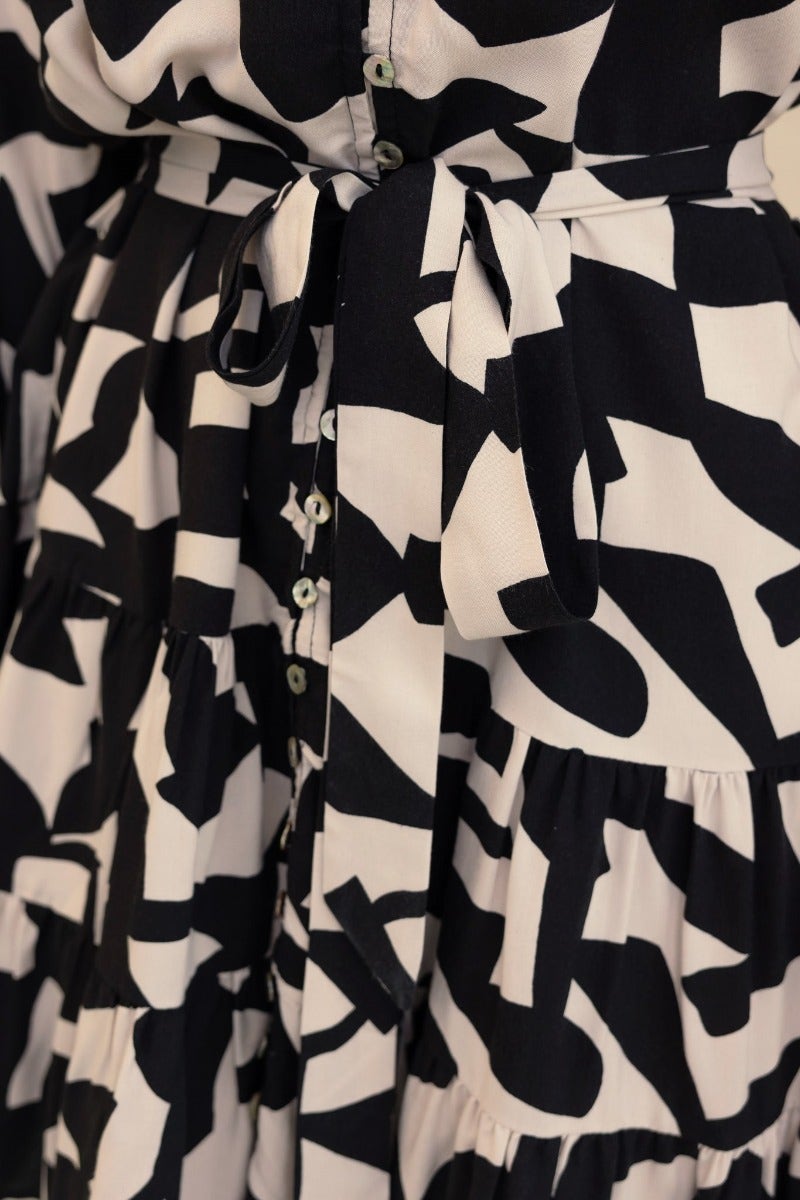 Close-up of Hasley Dress featuring a black and white print, button-up front, and removable fabric belt.