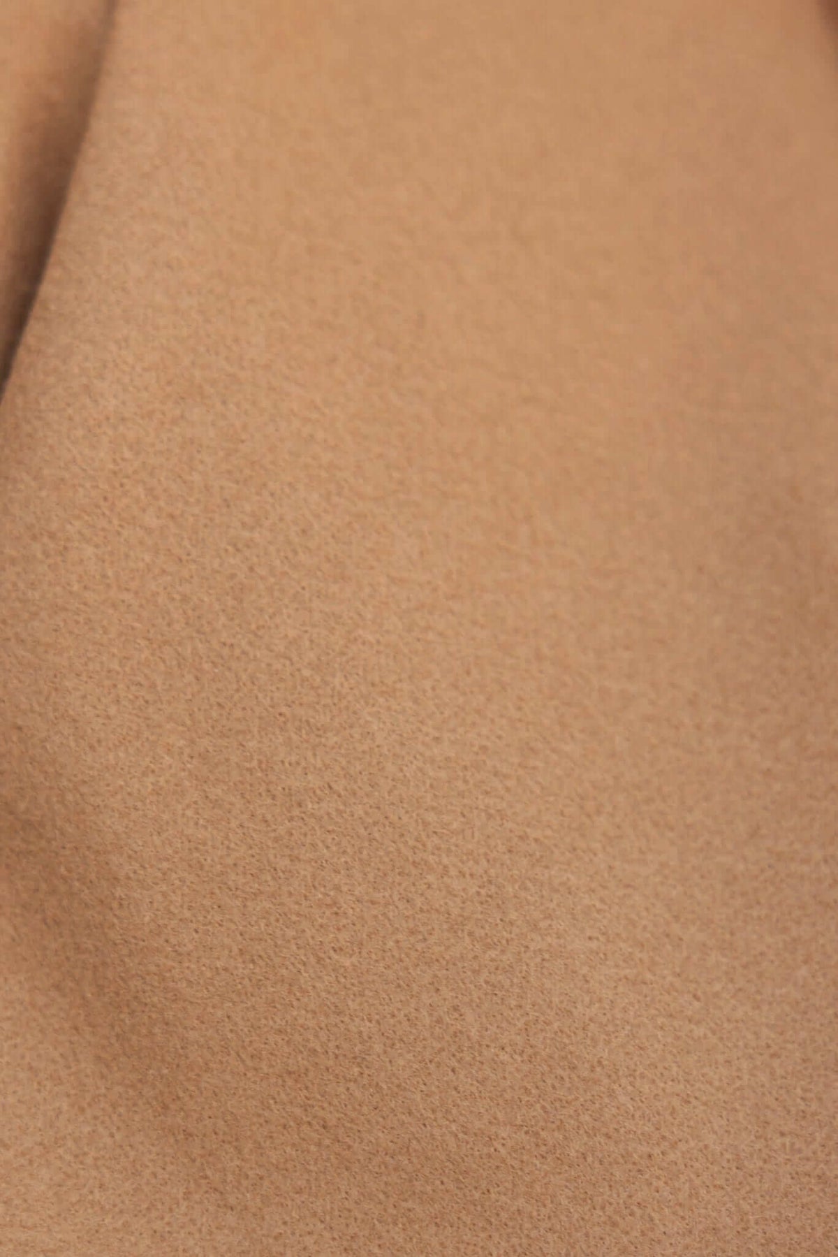 Close-up of soft beige fabric texture for a Jean Coat, showcasing smooth, non-stretch material ideal for stylish outerwear.