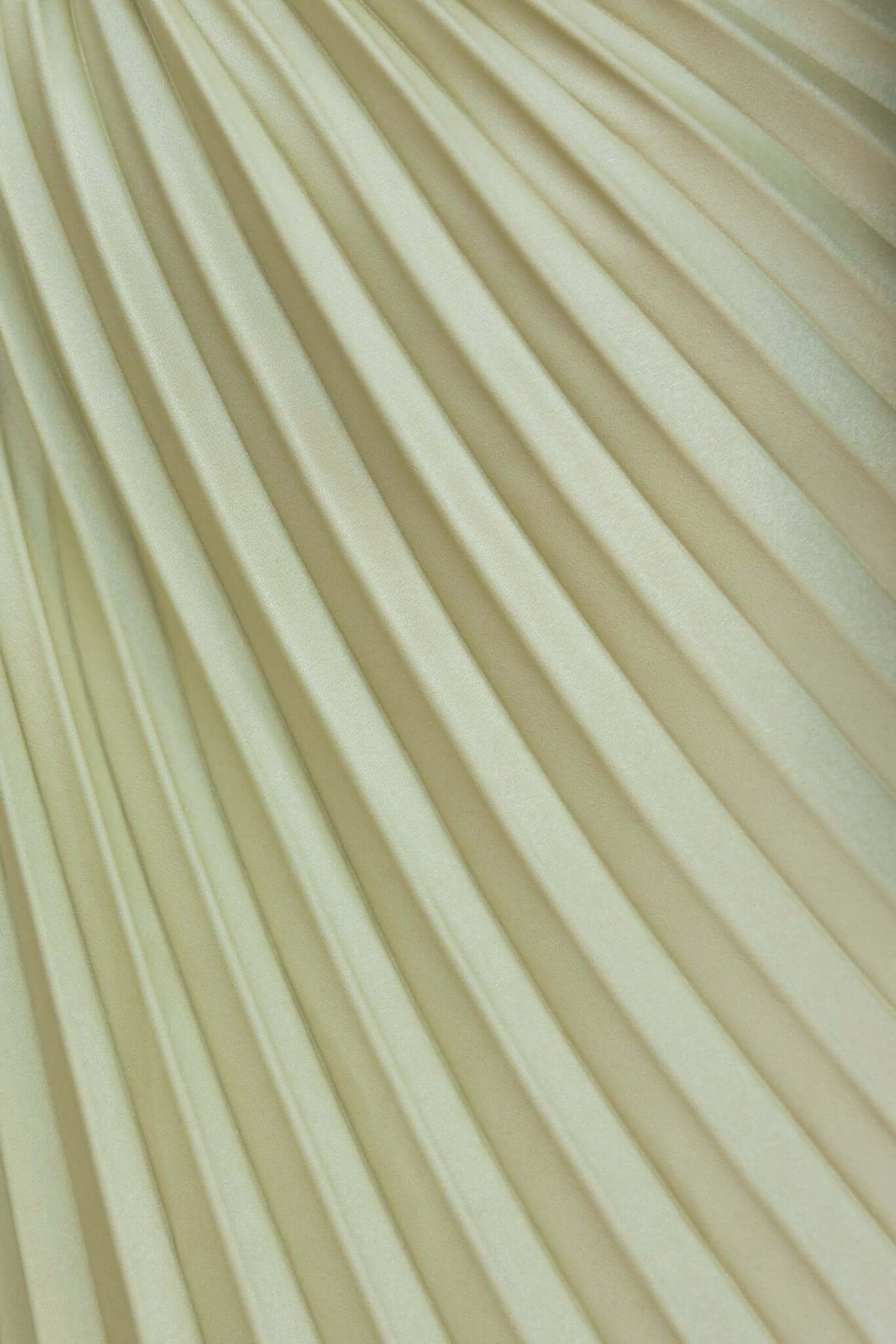 Close-up of pleated satin fabric in soft cream color, showcasing elegant draping and texture for a refined look.