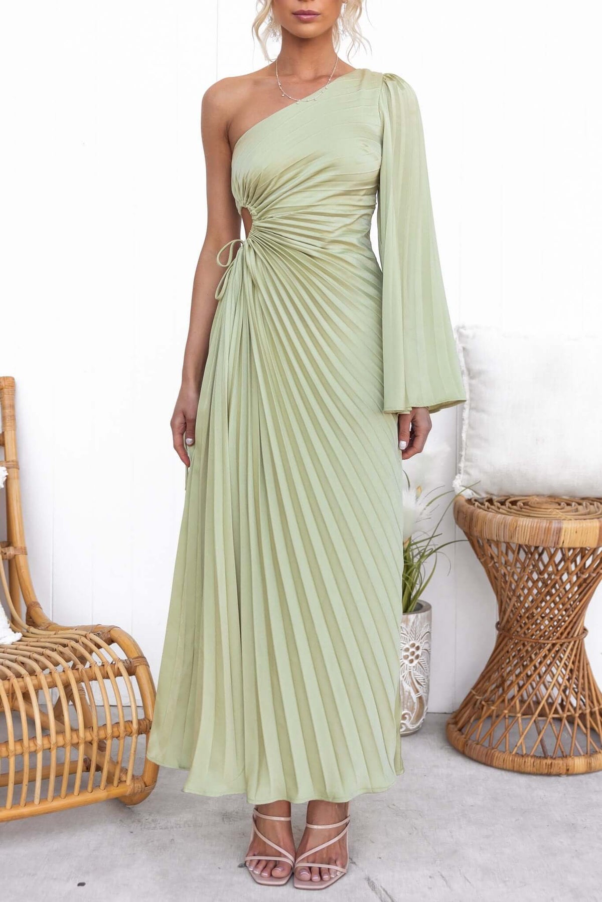 Elegant one-shoulder pleated maxi dress in soft green with waist cut-out and drawstring tie, perfect for formal occasions.