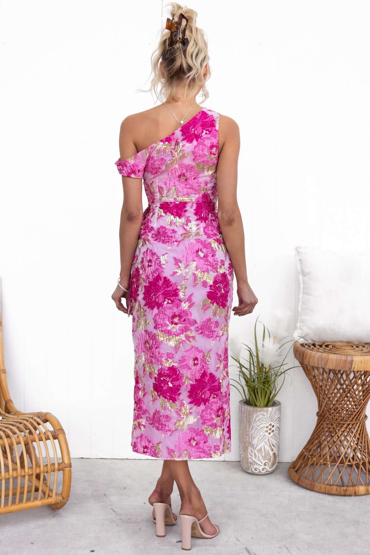 Back view of Bettina Midi Dress featuring pink floral pattern and asymmetric neckline, perfect for stylish summer occasions.