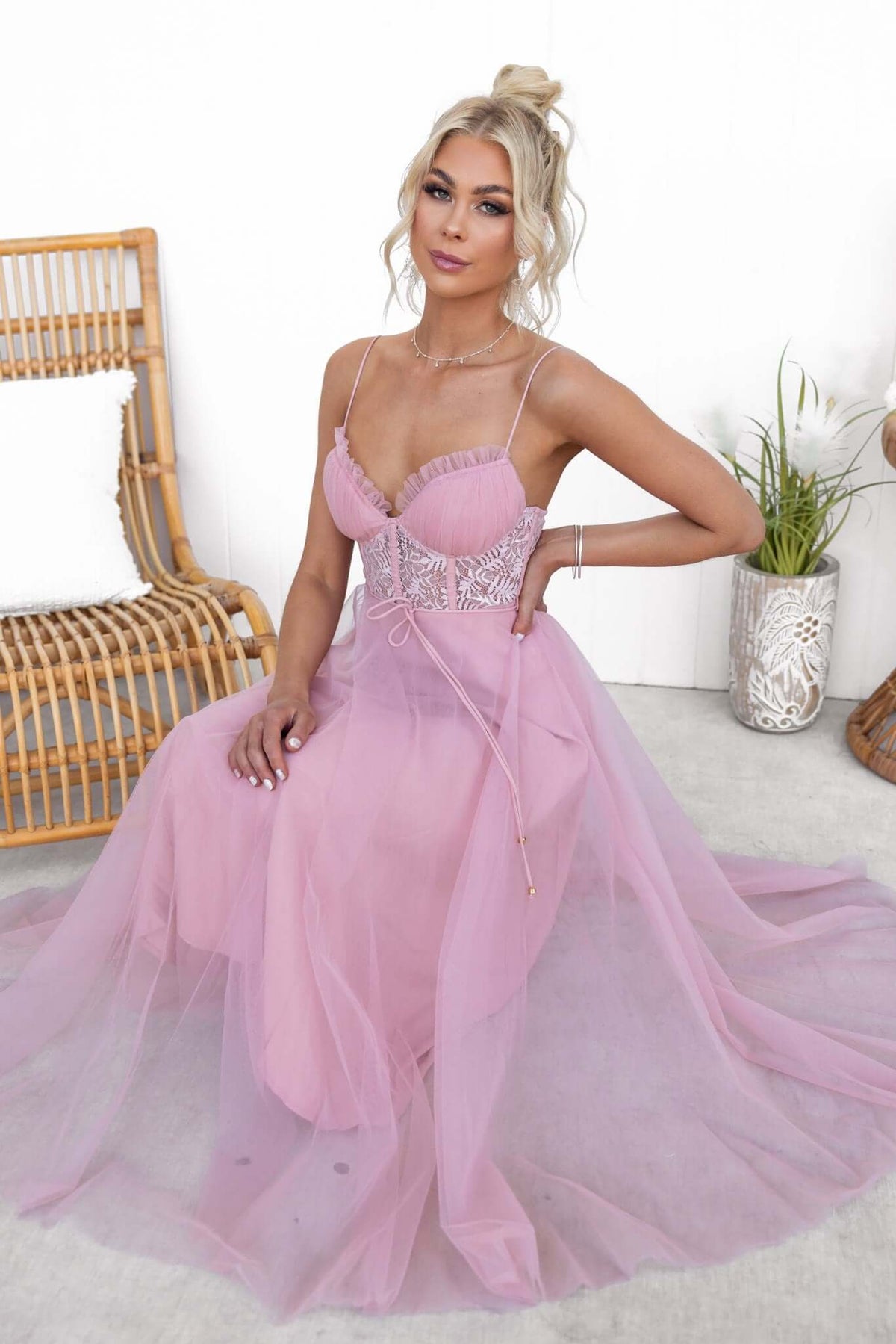 Model wearing a pink tulle Wash Away Maxi Dress with adjustable straps and lace details.