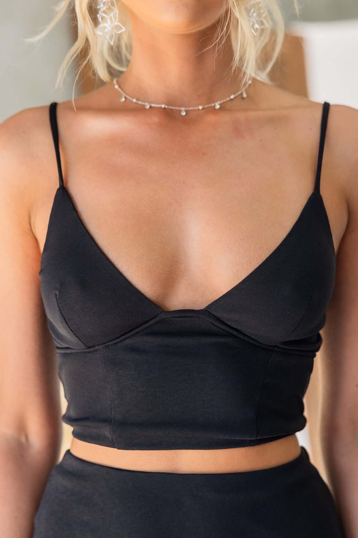 Black Idol Top with adjustable straps and a stylish lined design, perfect for a sleek, modern look.