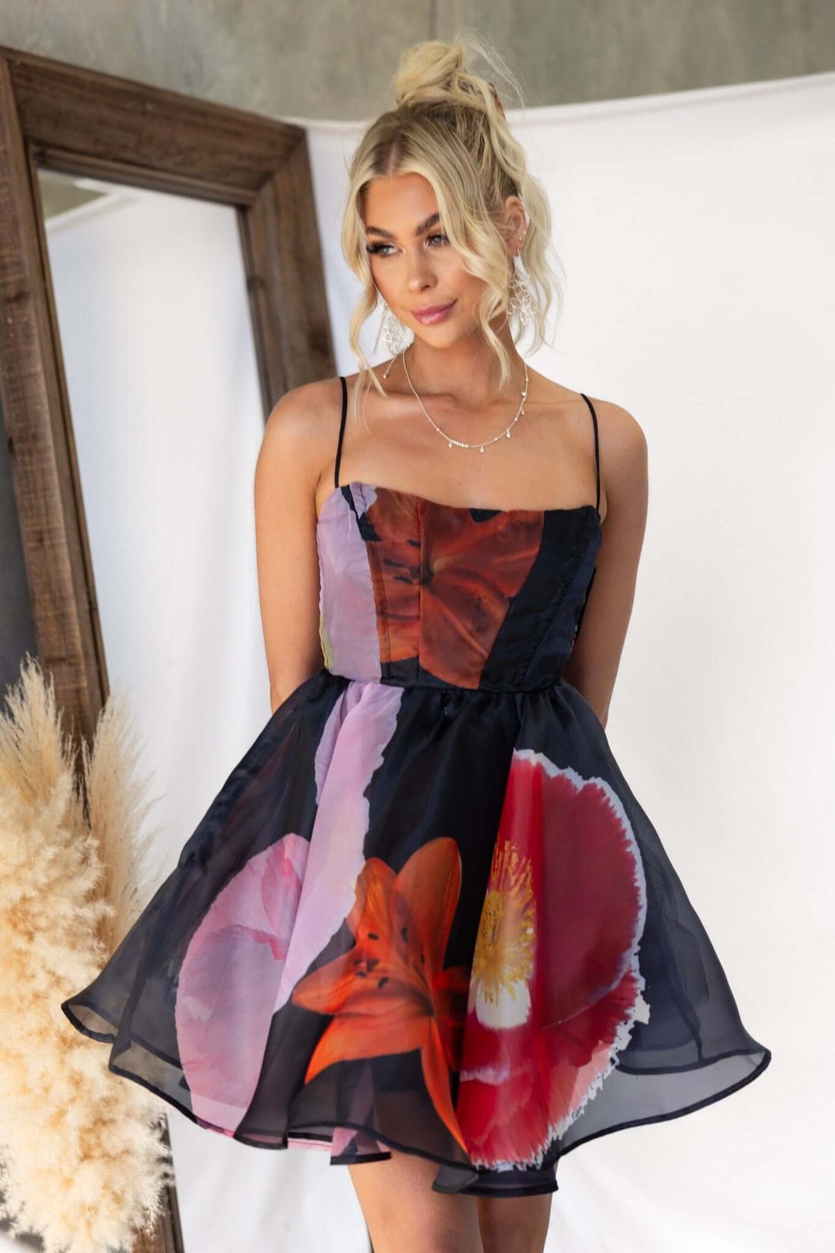 Rosebud Dress featuring vibrant floral print, adjustable straps, and a flared skirt, perfect for summer outings.