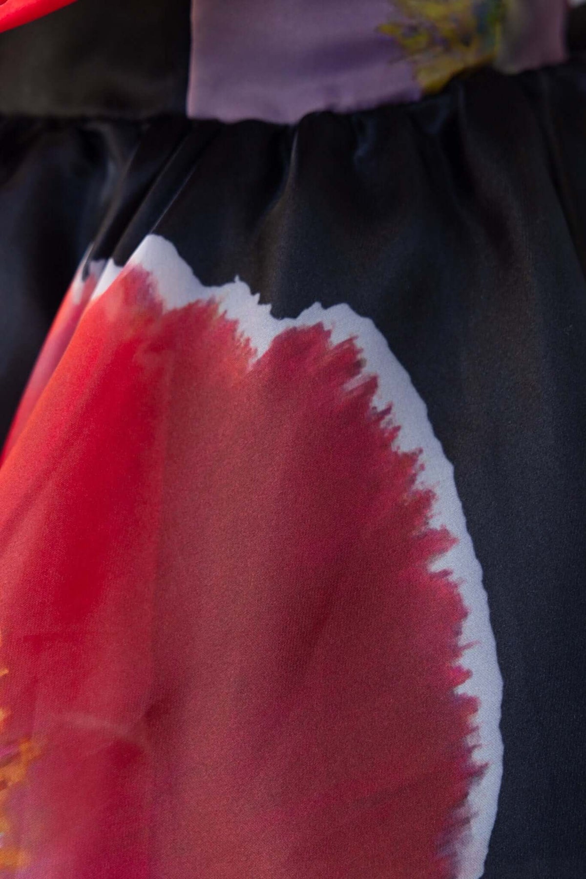 Close-up of the Rosebud Dress showing vibrant floral print and pleated detail.