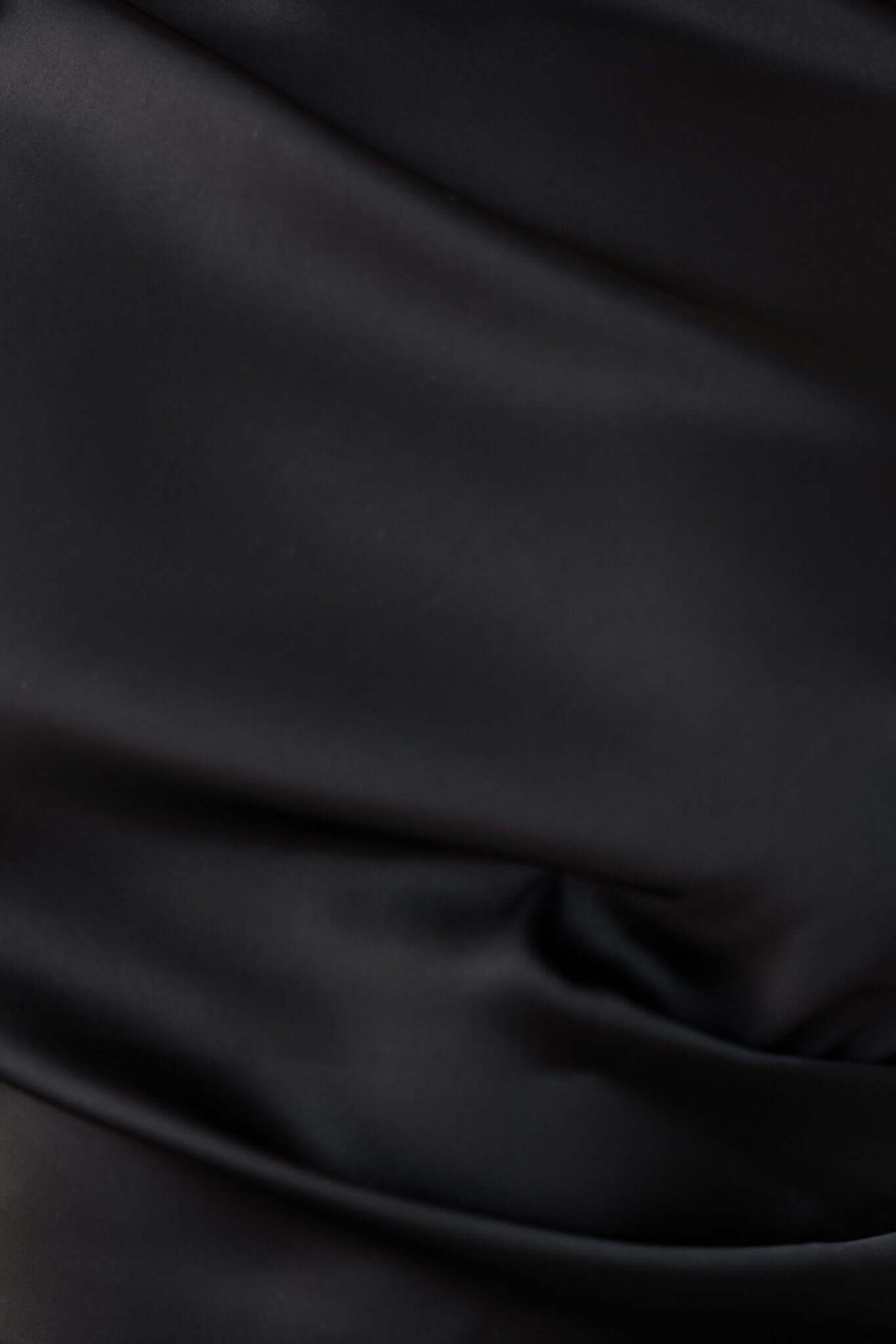 Close-up of the luxurious satin fabric of the Levona Maxi Dress in black, showcasing its smooth and elegant texture.