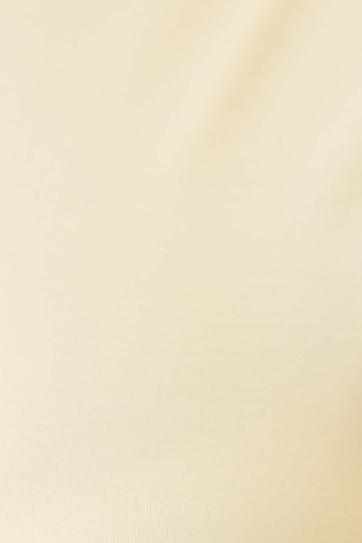 Close-up of a soft, smooth fabric in a light cream color, perfect for showcasing a comfortable cotton blend top.