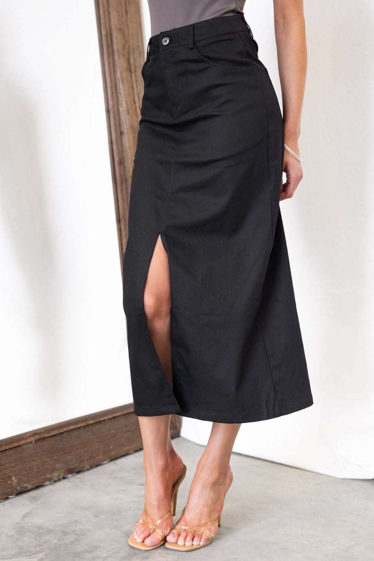 Burbank Midi Skirt in black with front split, mid-high waist fit, and pockets, perfect for a stylish look.