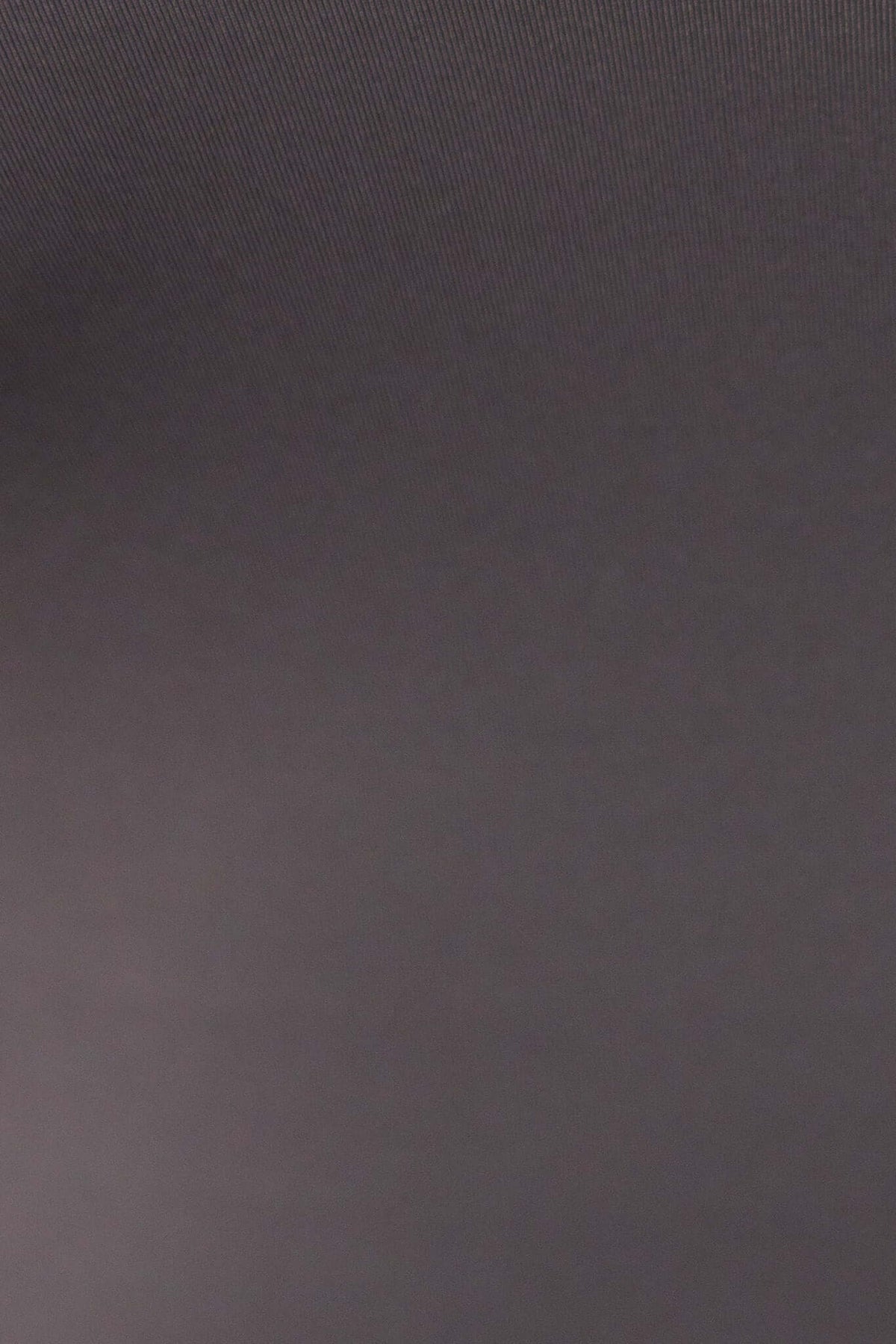 Close-up of thick structured material in a dark color, highlighting stretch and softness for the Jenna Bodysuit.