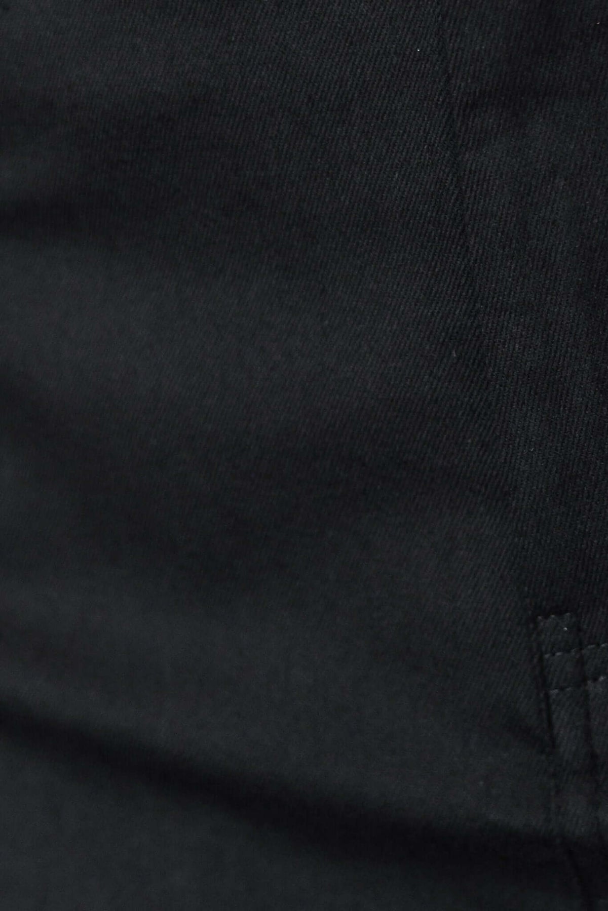 Close-up of black fabric texture from Burbank Midi Skirt, highlighting its stretch material.