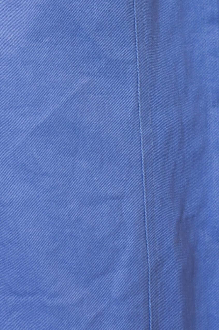 Close-up of a blue denim fabric showing texture and seam detail of the Kinston Denim Midi Dress.