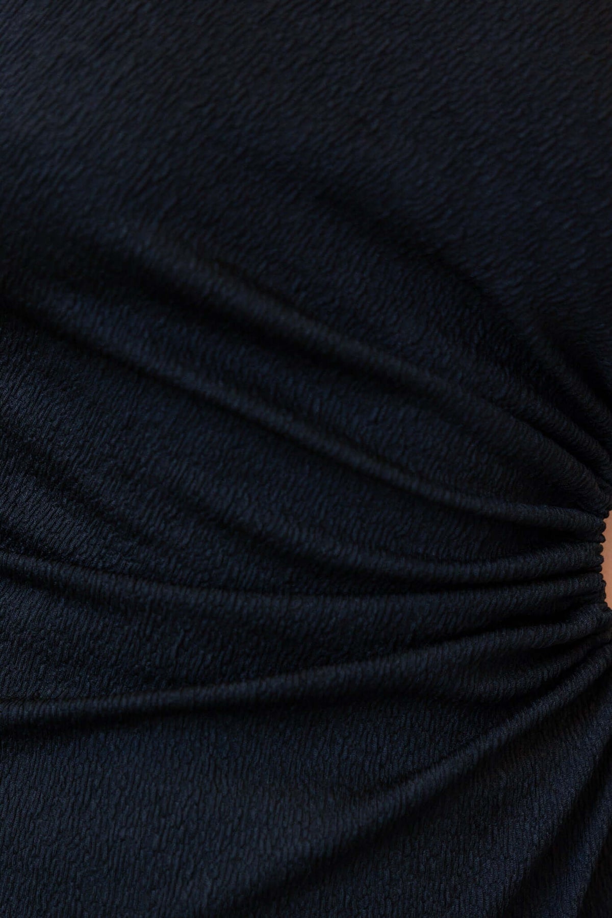 Close-up of the textured fabric of the black Romney Maxi Dress featuring elegant ruching details.