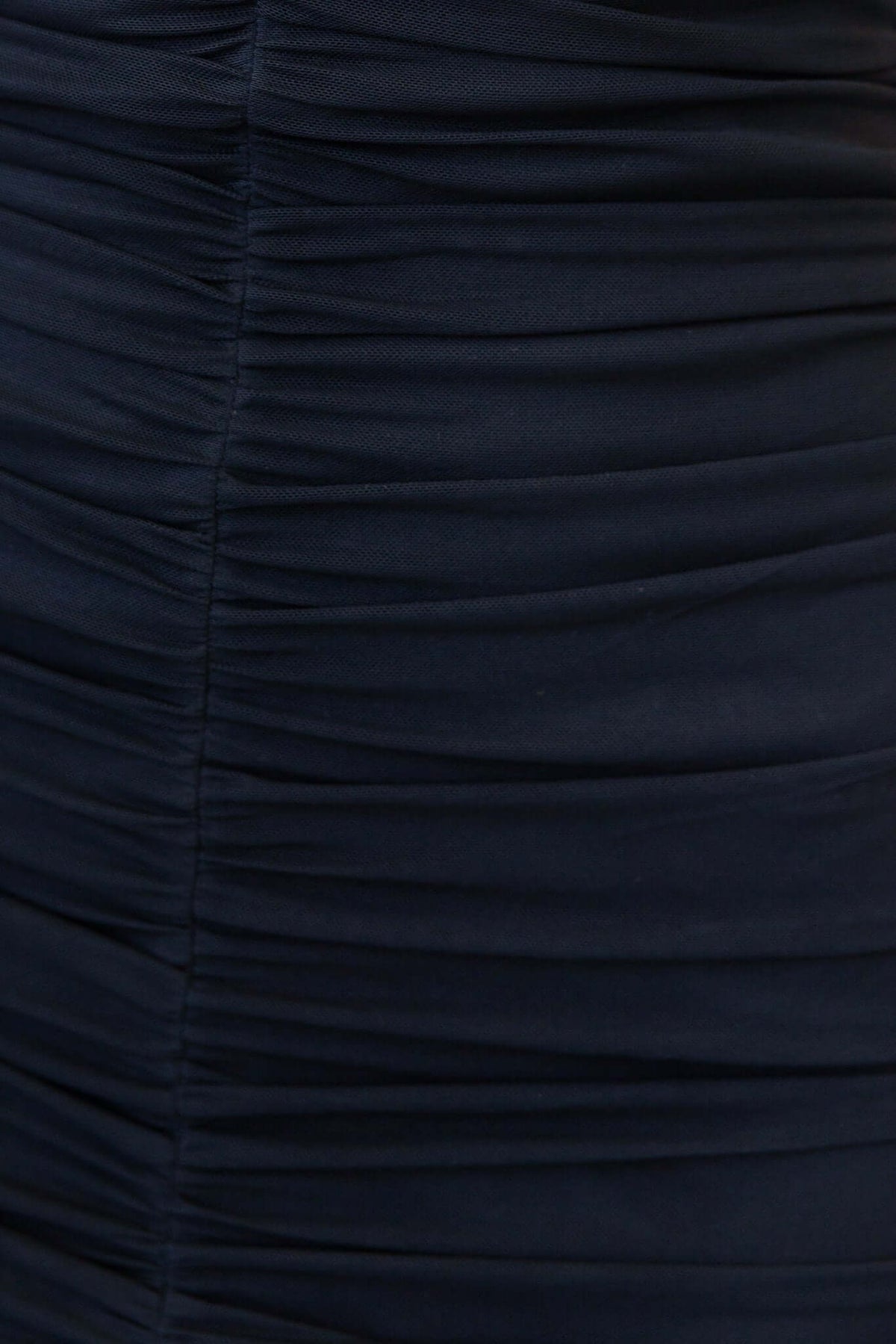 Close-up of the ruched fabric texture of a black maxi dress, showcasing its stretch and elegant design.