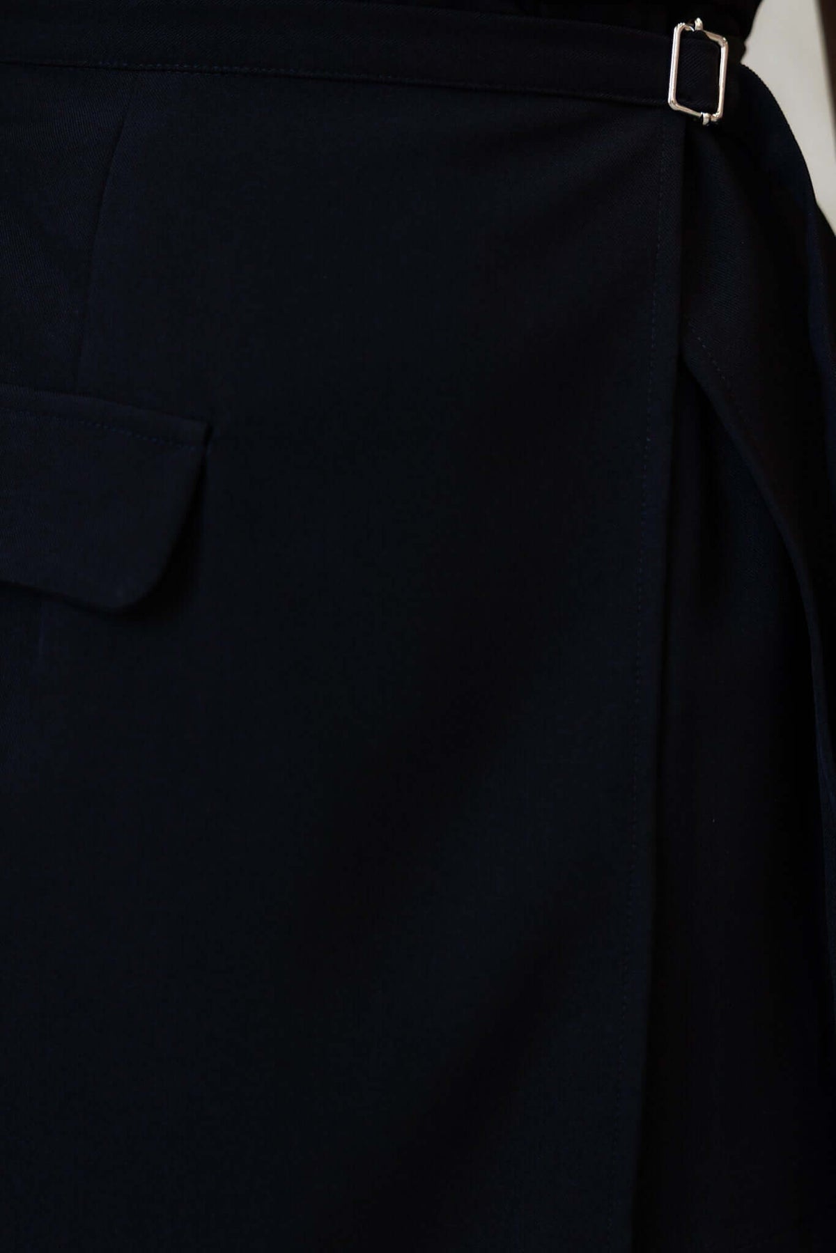 Close-up of the Martel Playsuit showing the wrap look detail and belt buckle in black fabric.