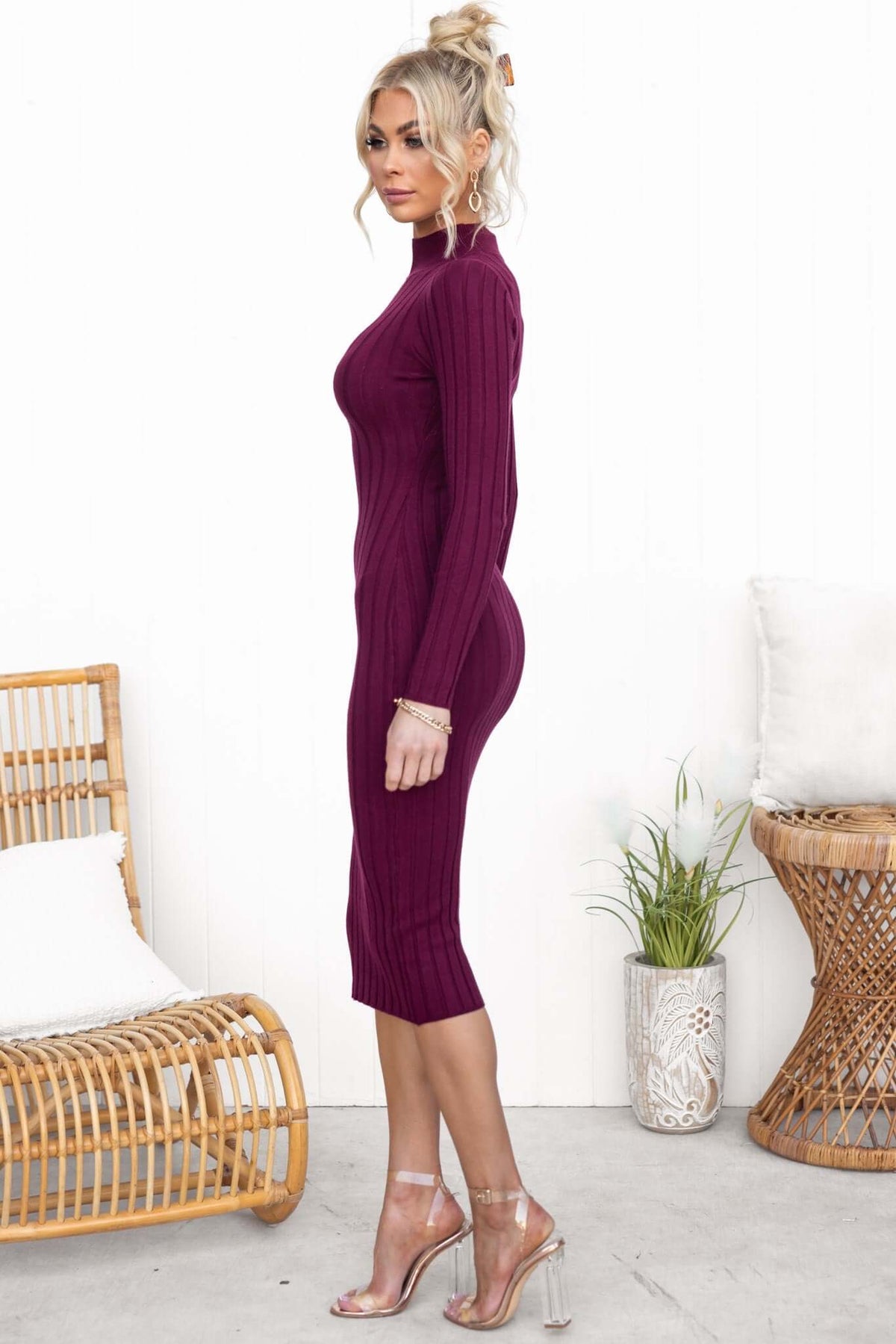 Model wearing a burgundy Bonners Midi Dress with a high neckline and ribbed knit texture, styled with clear heels.