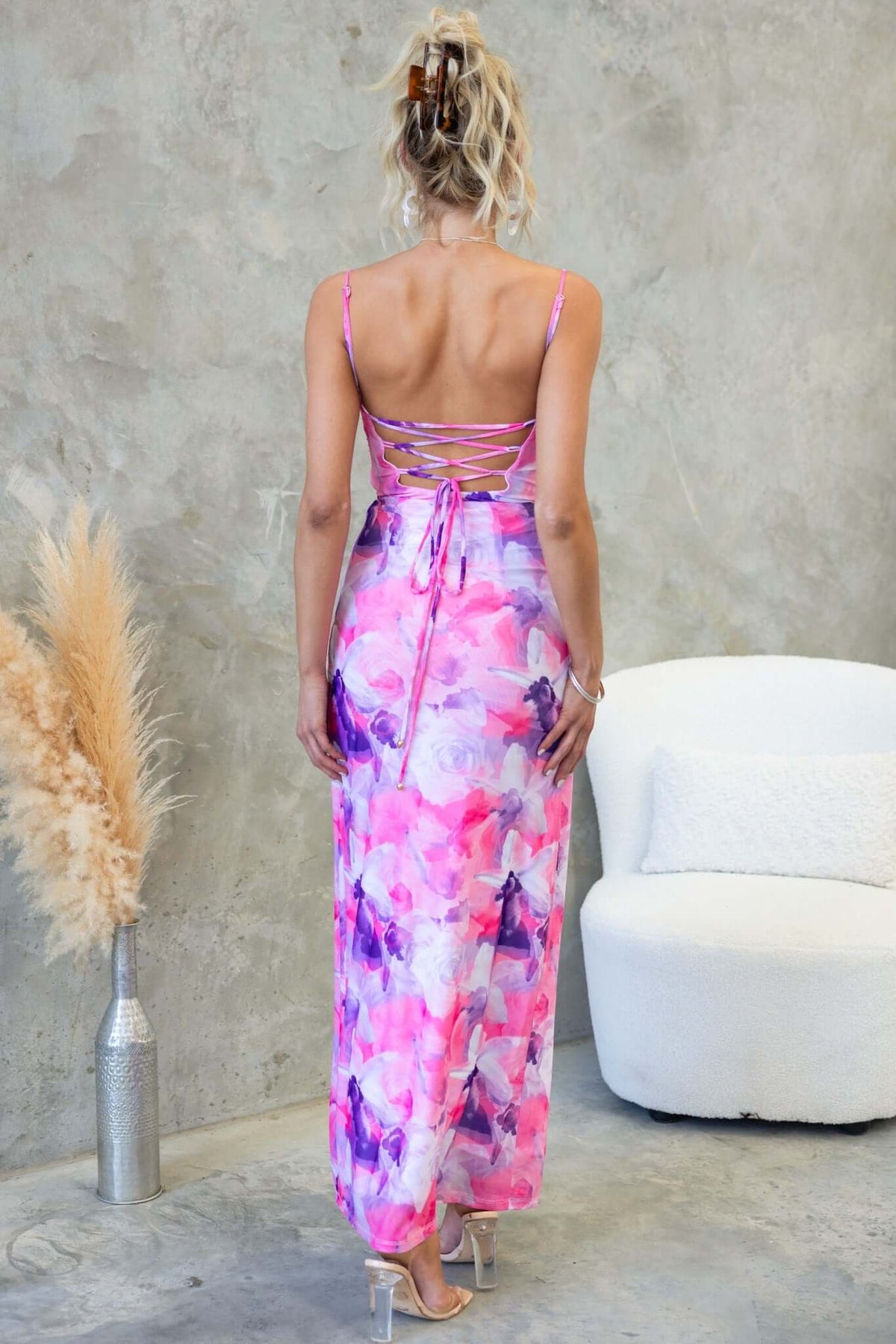 Back view of woman in Cranley Maxi Dress with adjustable straps and tie detail, featuring vibrant floral patterns.