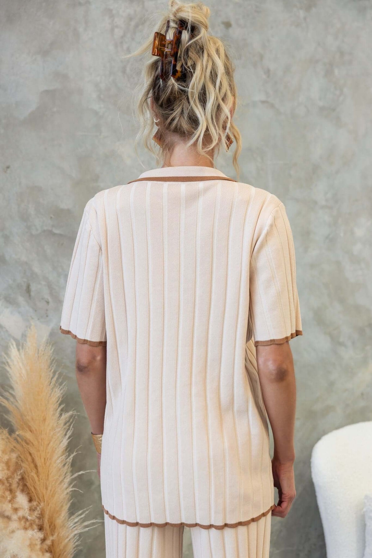 Back view of the Jodie Shirt in ribbed knit fabric, featuring a relaxed fit and short sleeves, styled with neutral decor.
