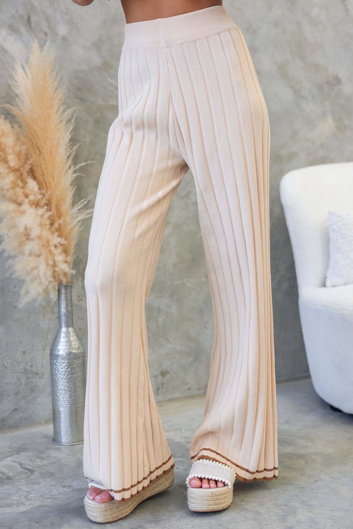 Jodie Pants in beige ribbed knit, mid-high waist with elastic waistband, styled with espadrille sandals.