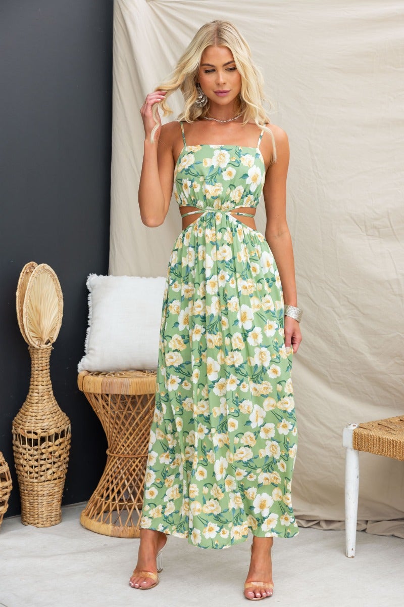 Model wearing a floral print Juliette maxi dress with adjustable straps and a cut-out waist.