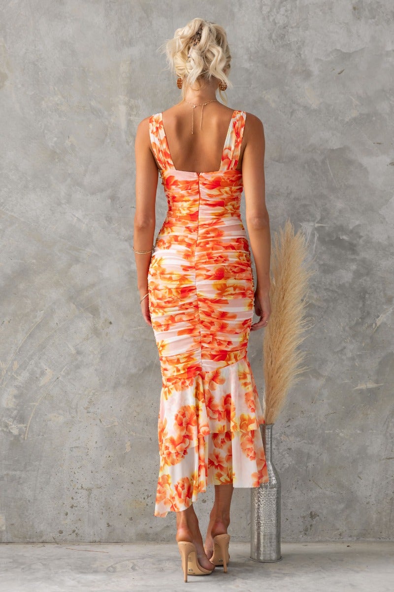 Model wearing the Zachia floral print maxi dress with asymmetric ruffle hem and ruched details from the back.