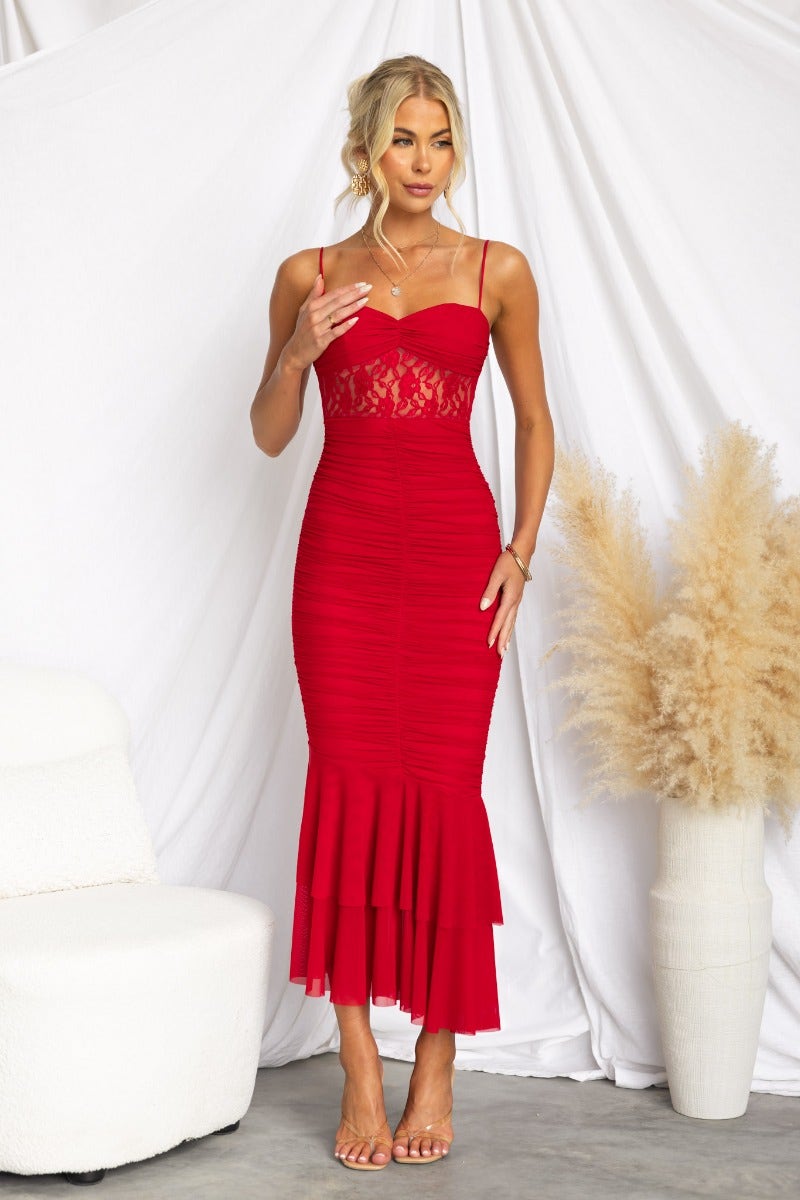 Model wearing an impressive red bodycon maxi dress with lace panel and ruched detail, styled with strappy heels.