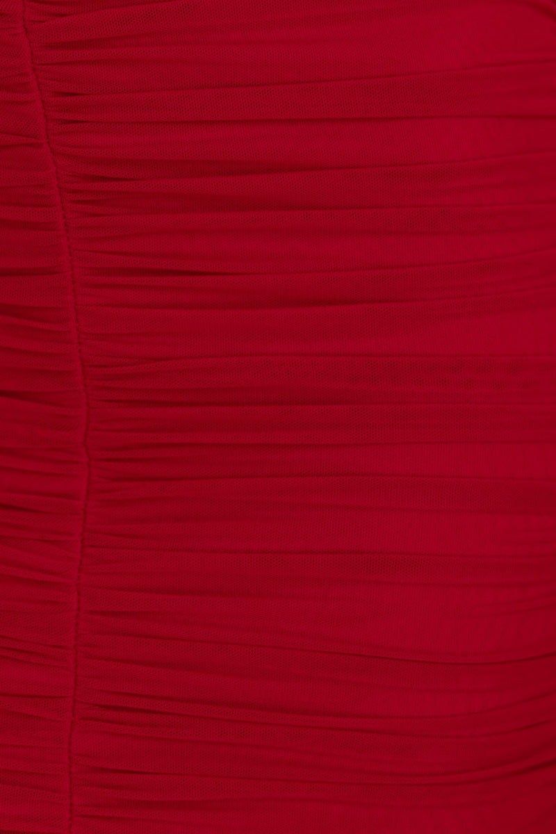 Close-up of red bodycon maxi dress fabric showing ruching detail and stretch material.