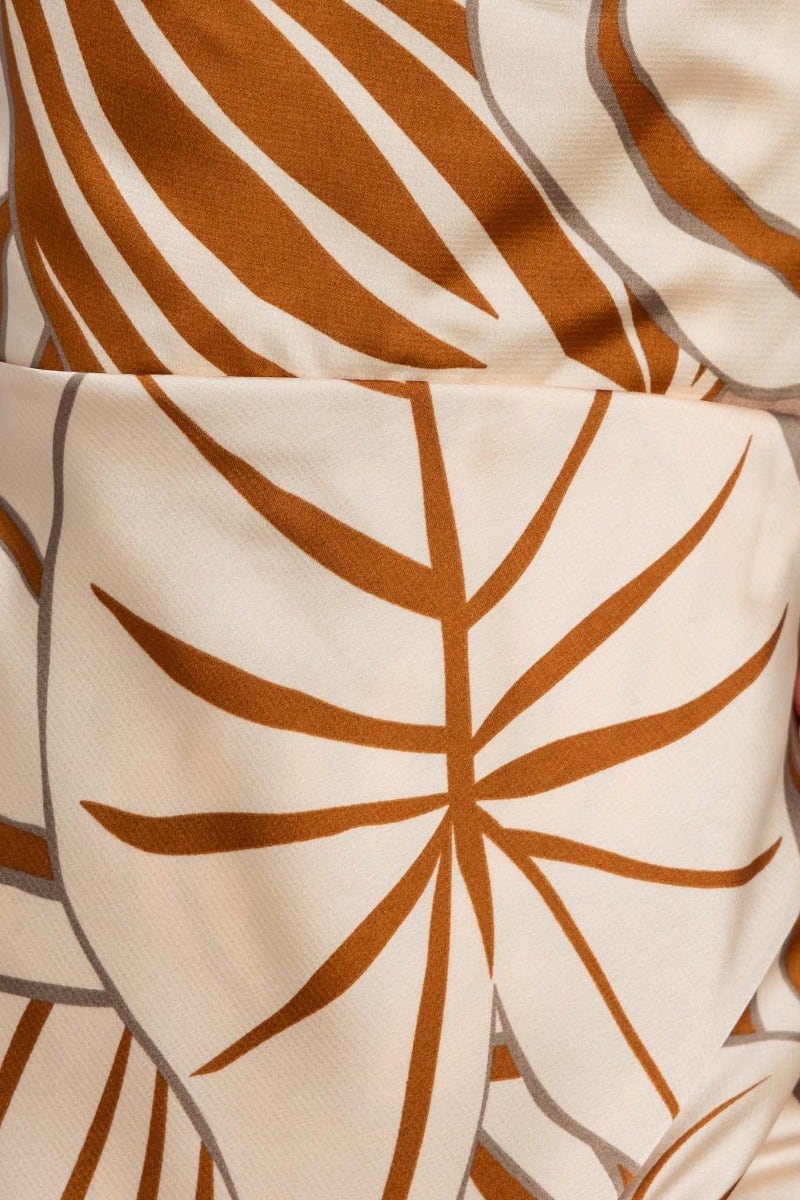 Close-up of floral print fabric featuring brown leaves on a cream background, perfect for a vibrant maxi dress.