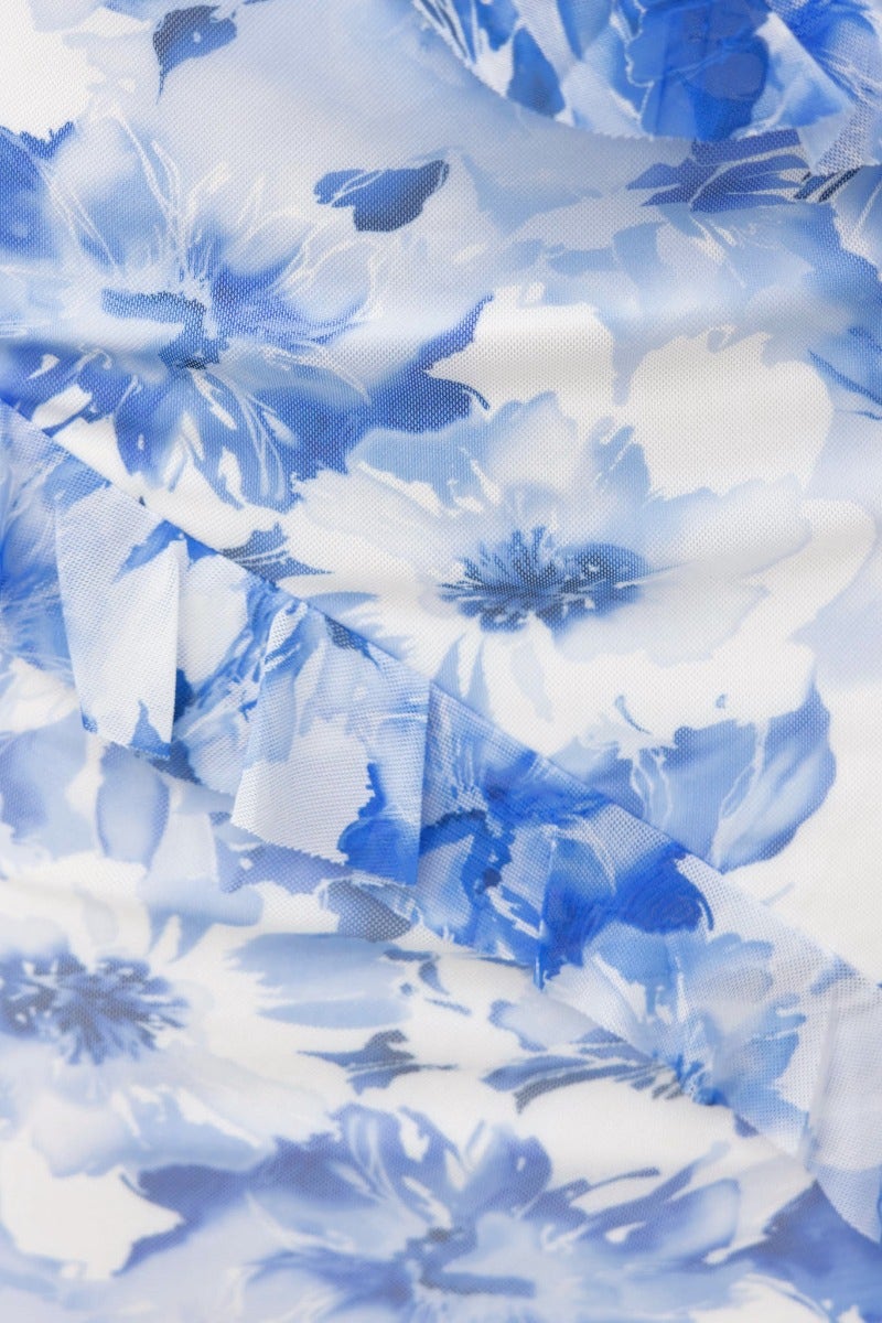 Close-up of floral print in blue on a lightweight fabric, featuring ruffles and mesh overlay for a maxi skirt.