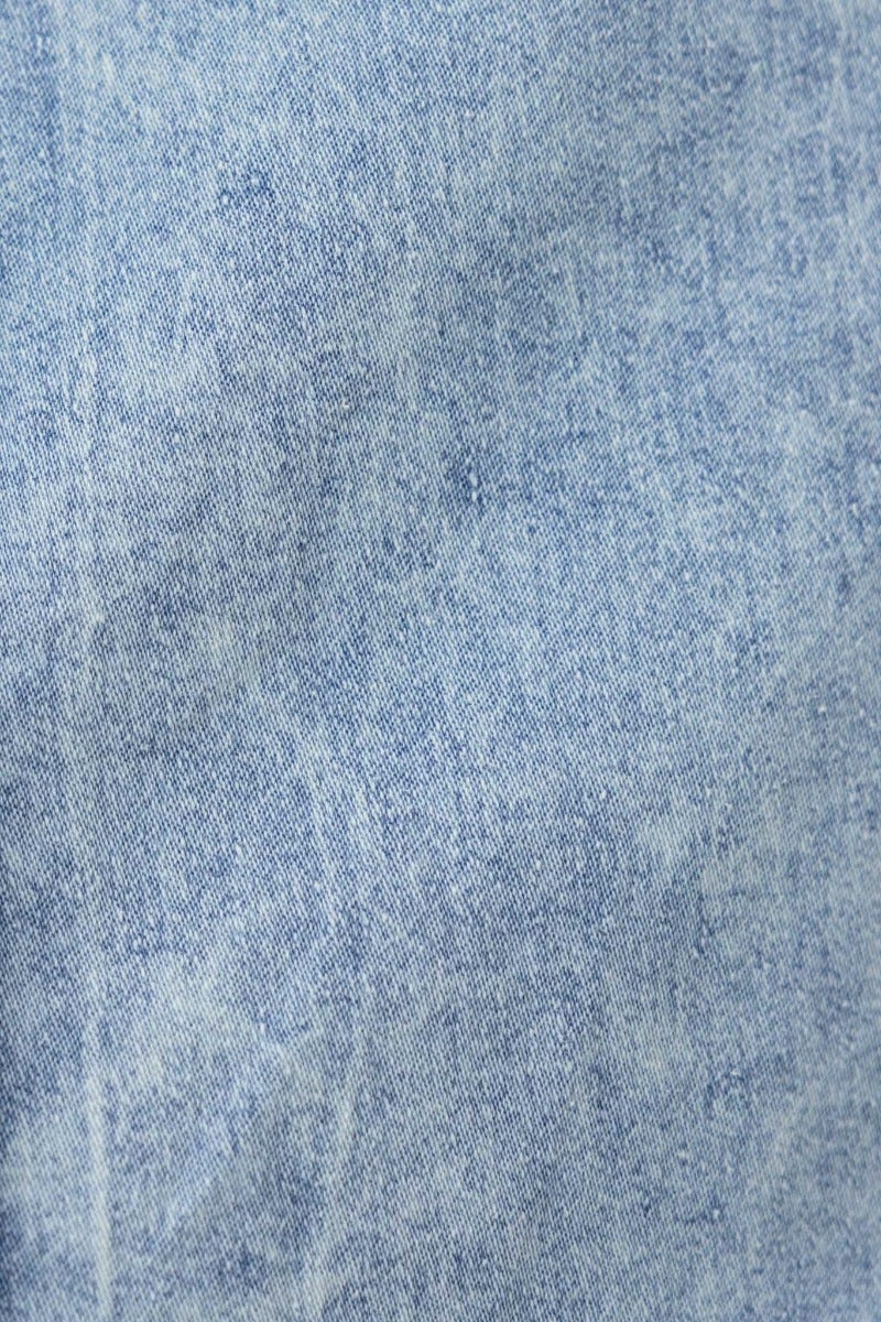 Close-up of soft denim fabric texture in light blue color, showcasing the unique wash for a stylish look.