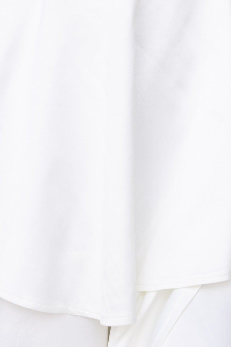 Close-up of the smooth, white fabric of the End Of Time Maxi Dress showcasing its satin look and ruffle design.