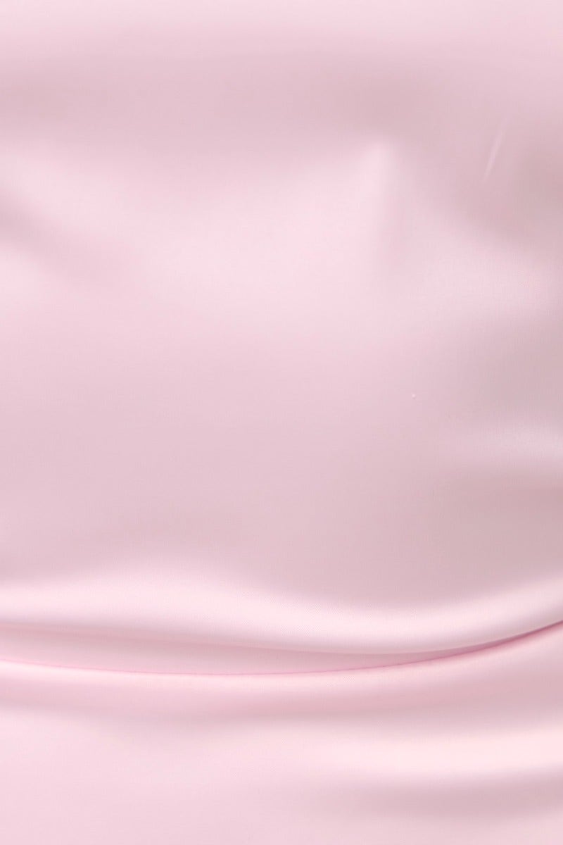 Close-up of soft pink satin fabric with smooth texture, highlighting the luxurious feel of the Astounding Maxi Dress.