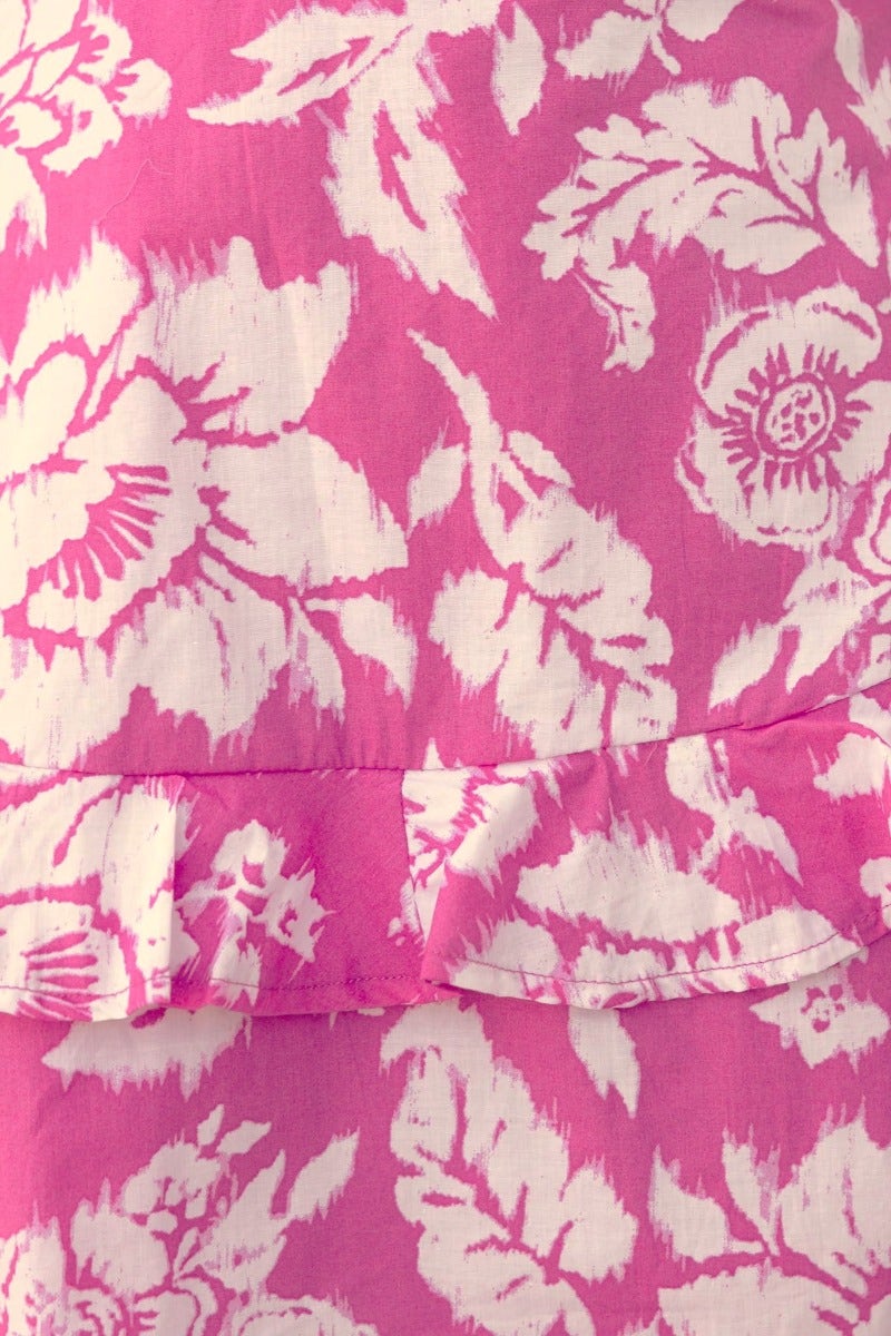 Close-up of floral print on the Change Me Dress in pink, featuring ruffled hem and white flower patterns.