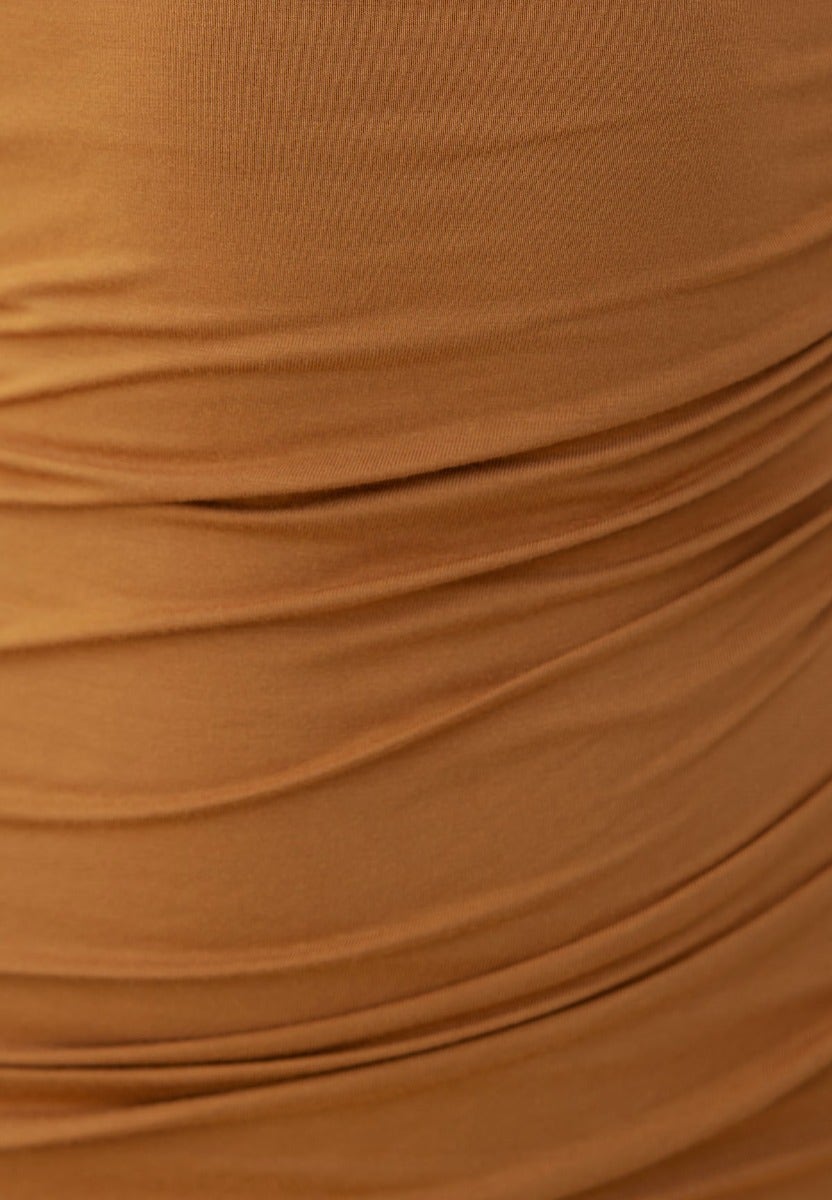 Close-up of ruched fabric in warm brown, showcasing soft cotton texture and stretch for bodycon dress design.