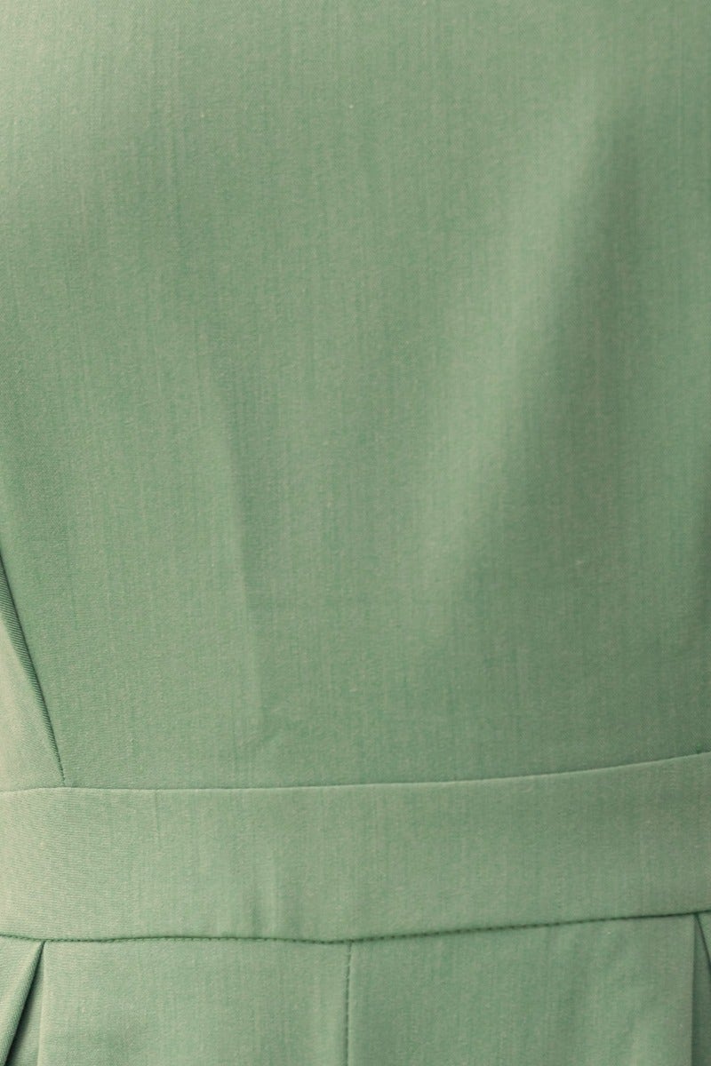 Close-up of the back of the Greta Jumpsuit featuring adjustable straps and a tie detail in soft green fabric.