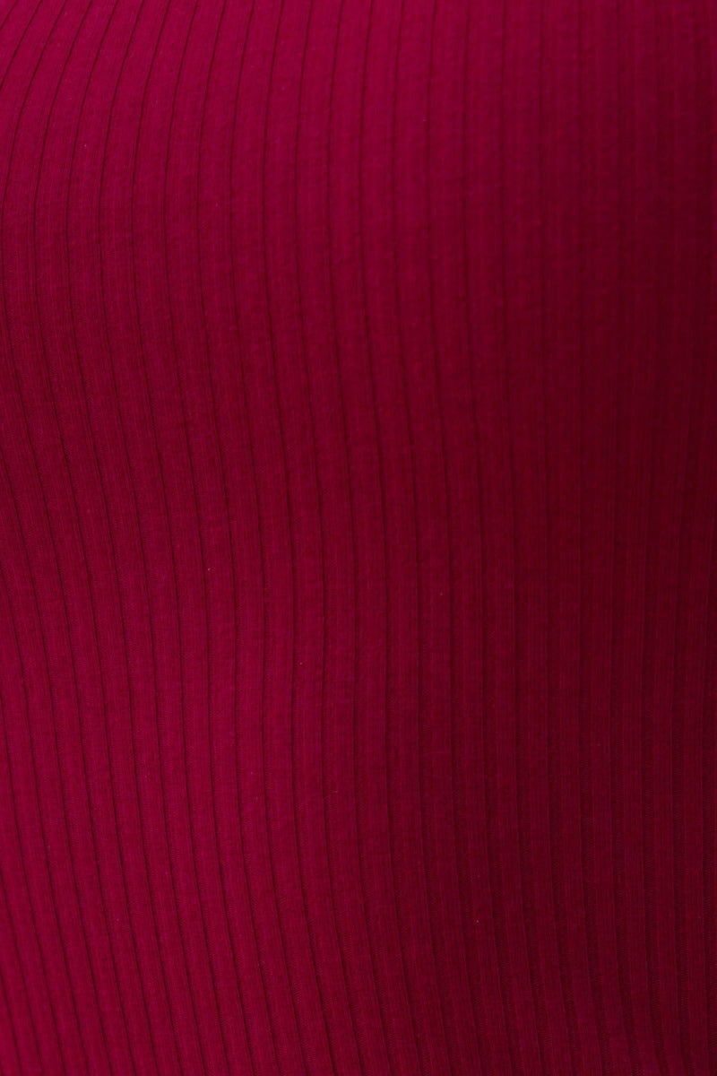 Close-up of soft ribbed fabric in deep burgundy for Knoxie Midi Dress, showcasing its stretch and texture.