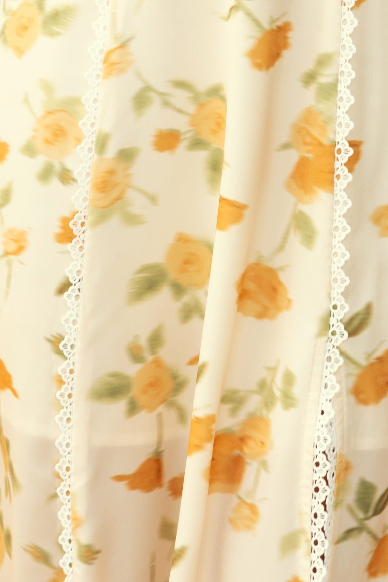 Close-up of floral print fabric in the Brigita Midi Dress, featuring lace detailing and soft satin look.