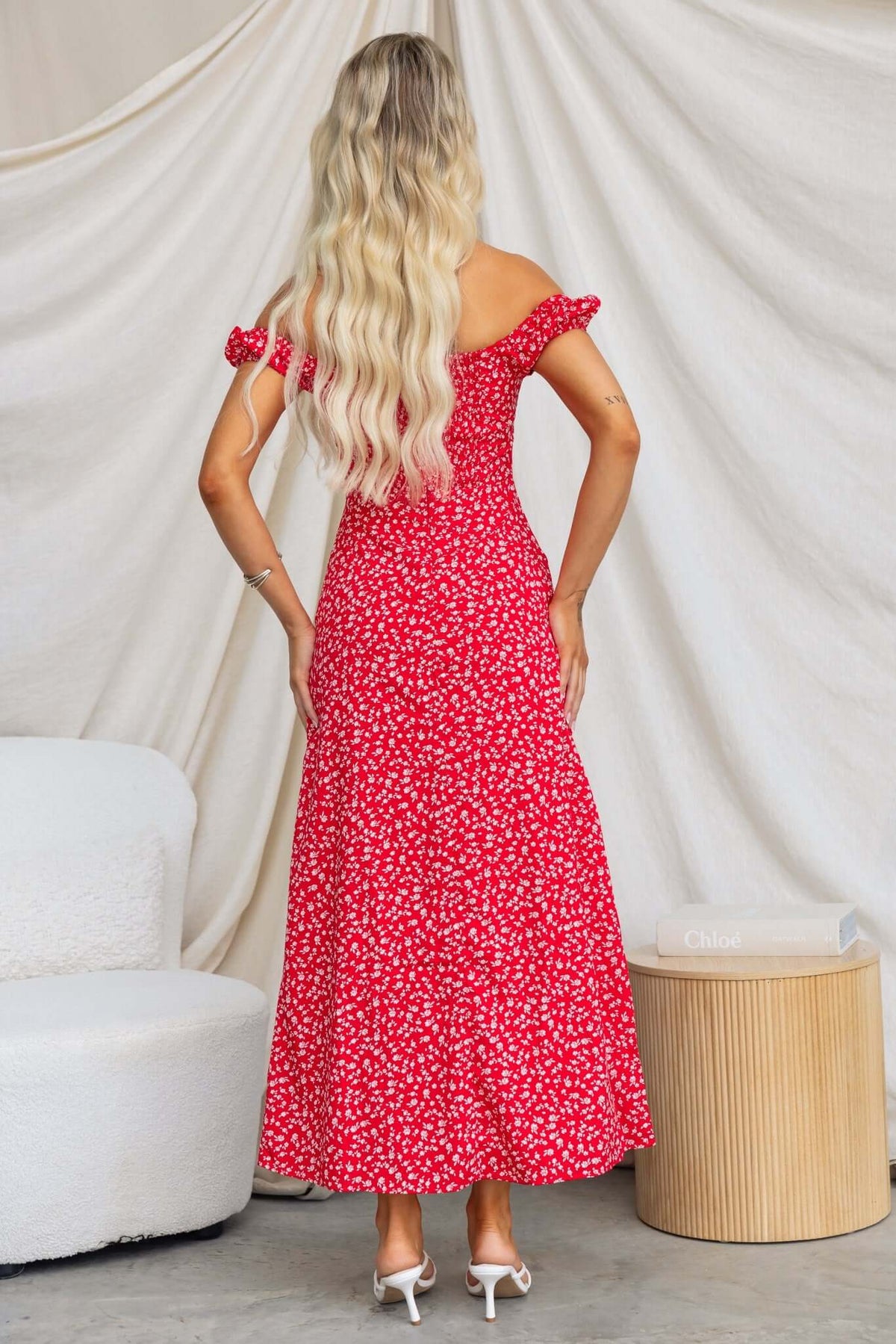 Model wearing Frankle Maxi Dress with floral pattern, showcasing back view and off-shoulder style.