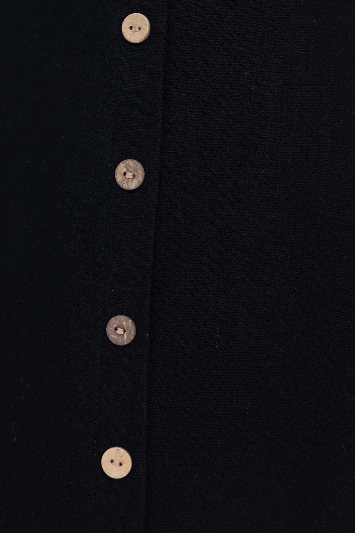 Close-up of faux buttons on a black maxi dress, highlighting the stylish detail and elegant design.