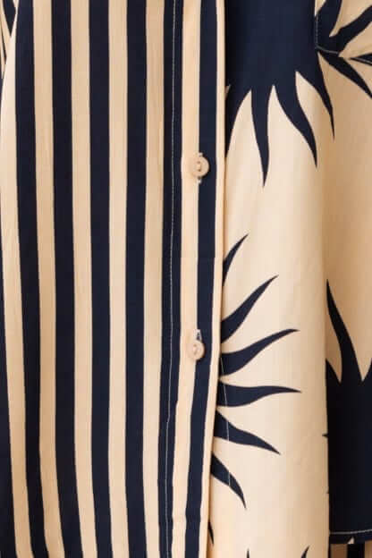 Close-up of Hadley Shorts fabric showing striped pattern and sun design with buttons.