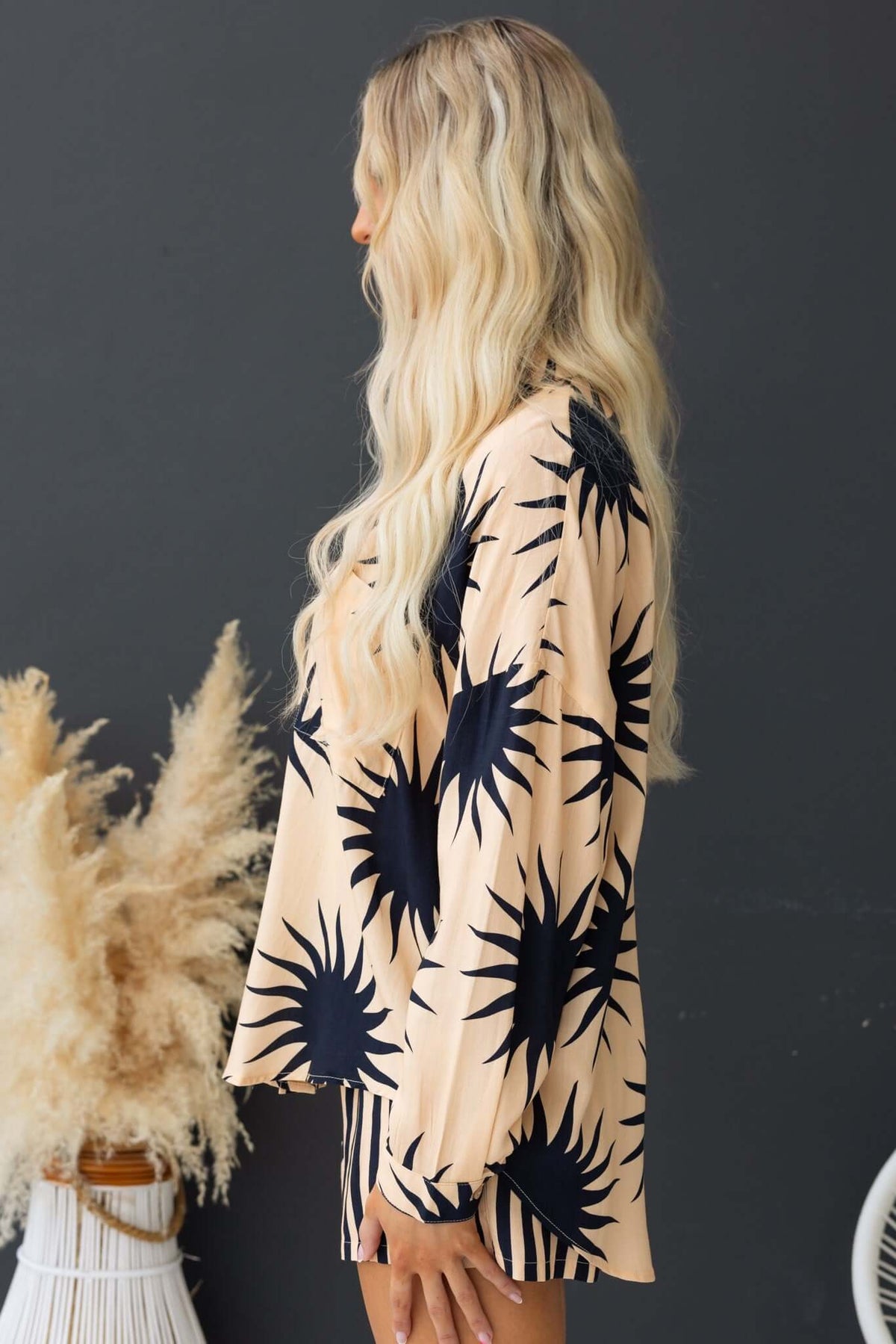 Side view of a model wearing a Hadley Shirt with sunburst print in peach and navy, styled with relaxed fit and open collar.