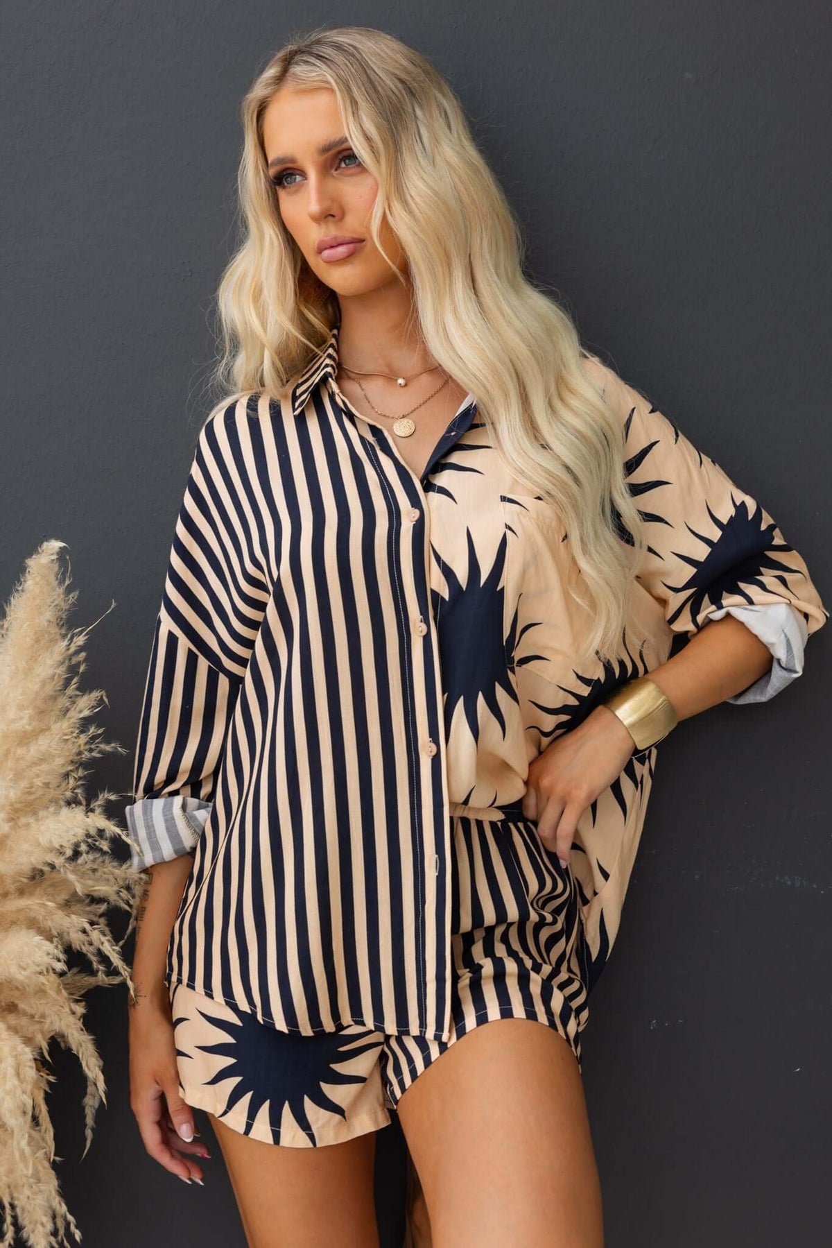 Model wearing Hadley Shorts with a matching shirt featuring stripes and sunburst design, showcasing a stylish casual look.