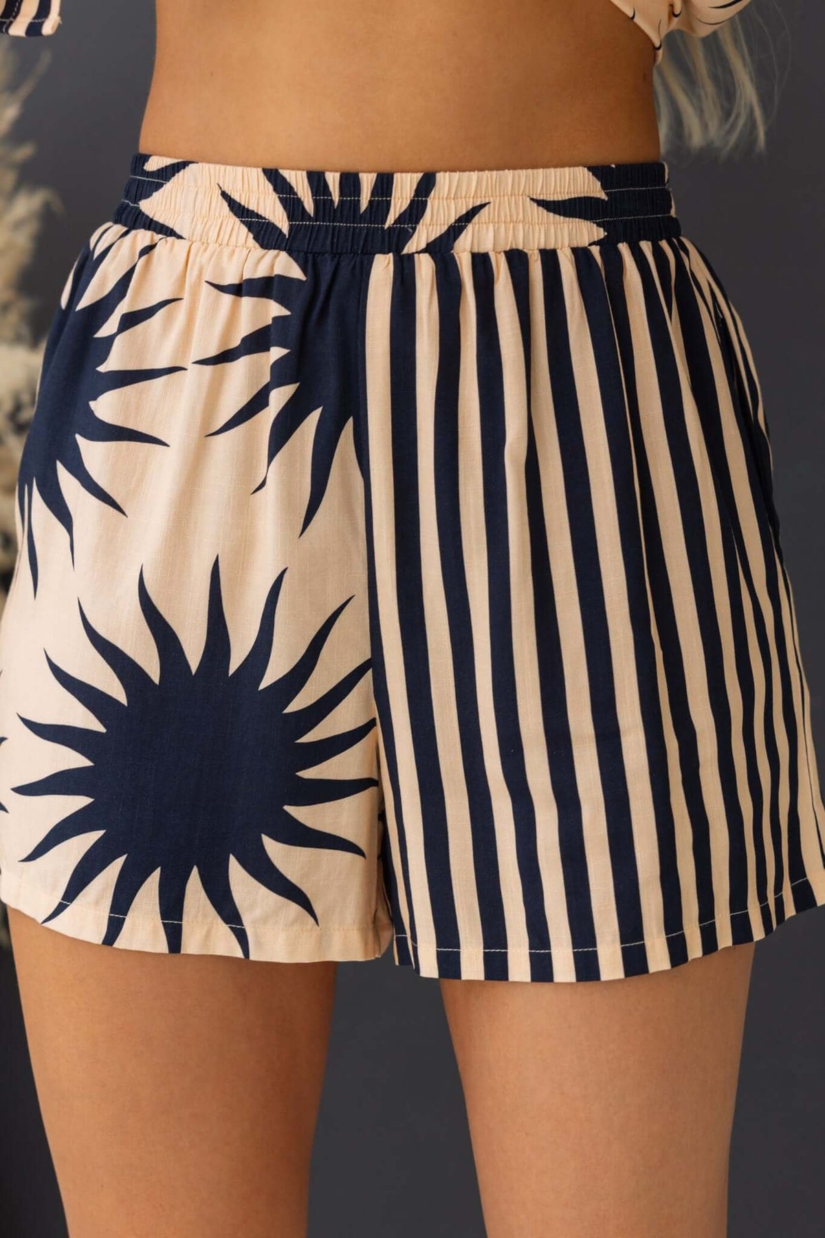 Hadley Shorts featuring a mid-high waist, elastic waistband, and unique sun and stripe pattern, perfect for summer style.